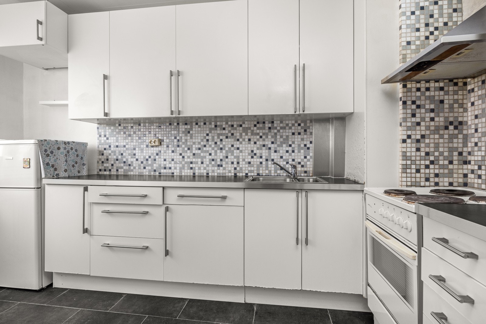 Separat kjøkken med kjøkkeninnredning med hvite slette fronter Galleribilde