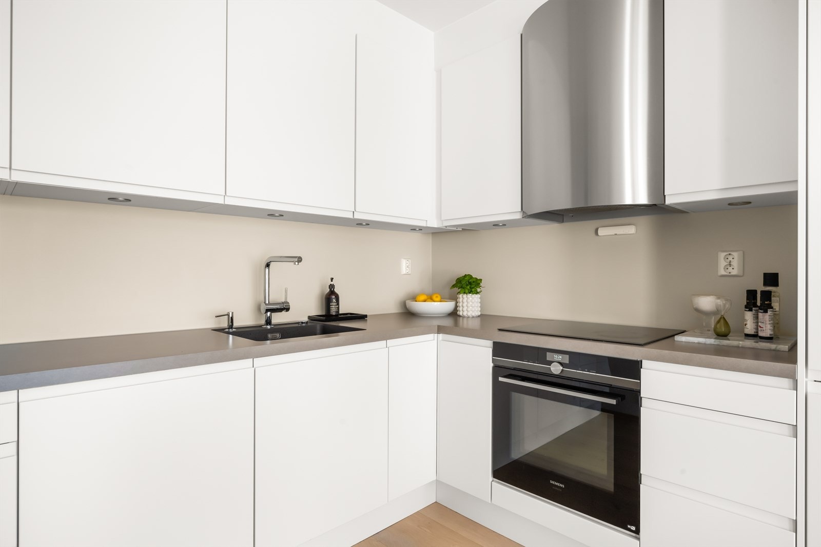 Tidsriktig innredning med glatte, hvite fronter og benkeplate i laminat Galleribilde