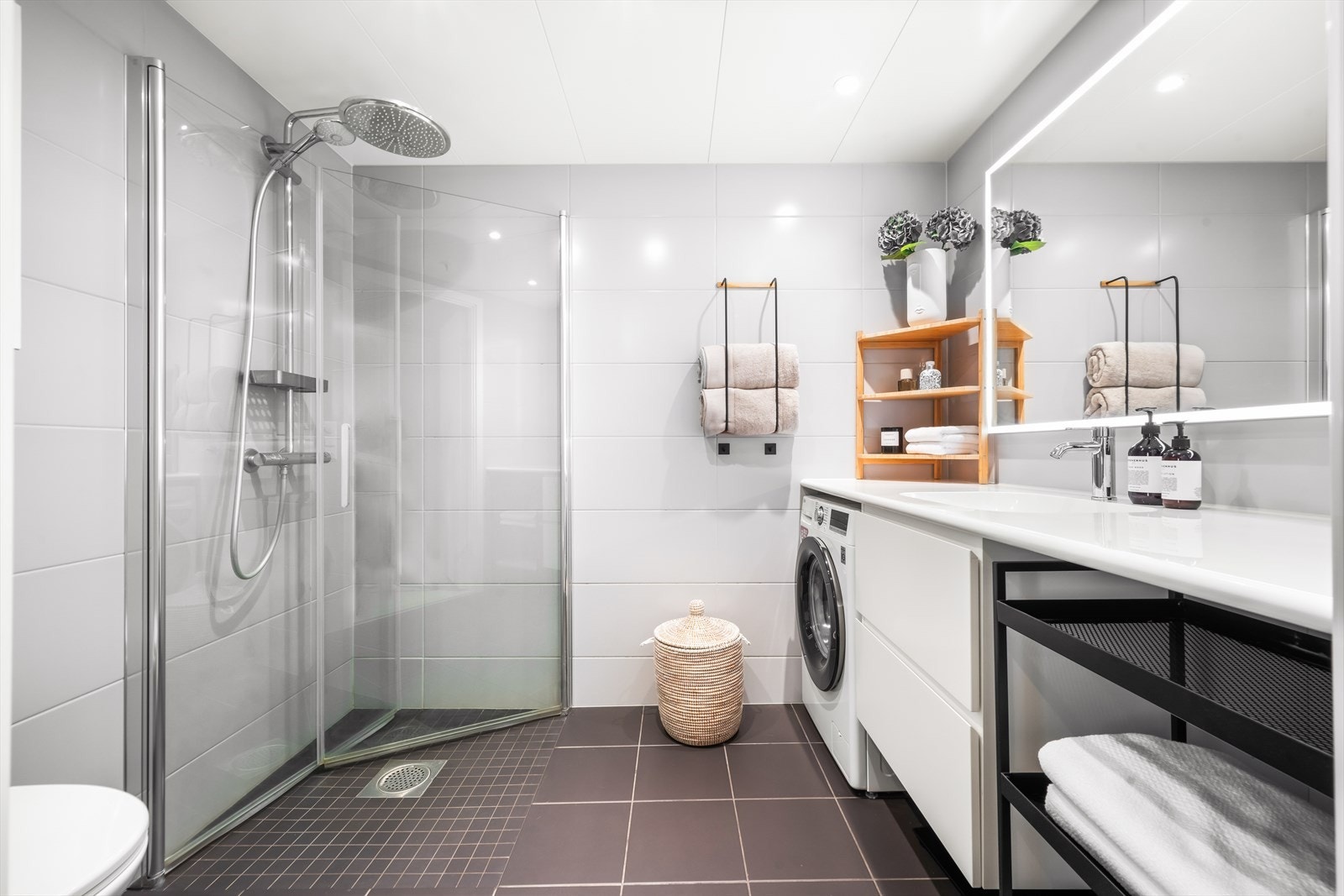 Delikat bad med flislagte overflater, elektrisk gulvvarme og innfelte downlights i himling Galleribilde