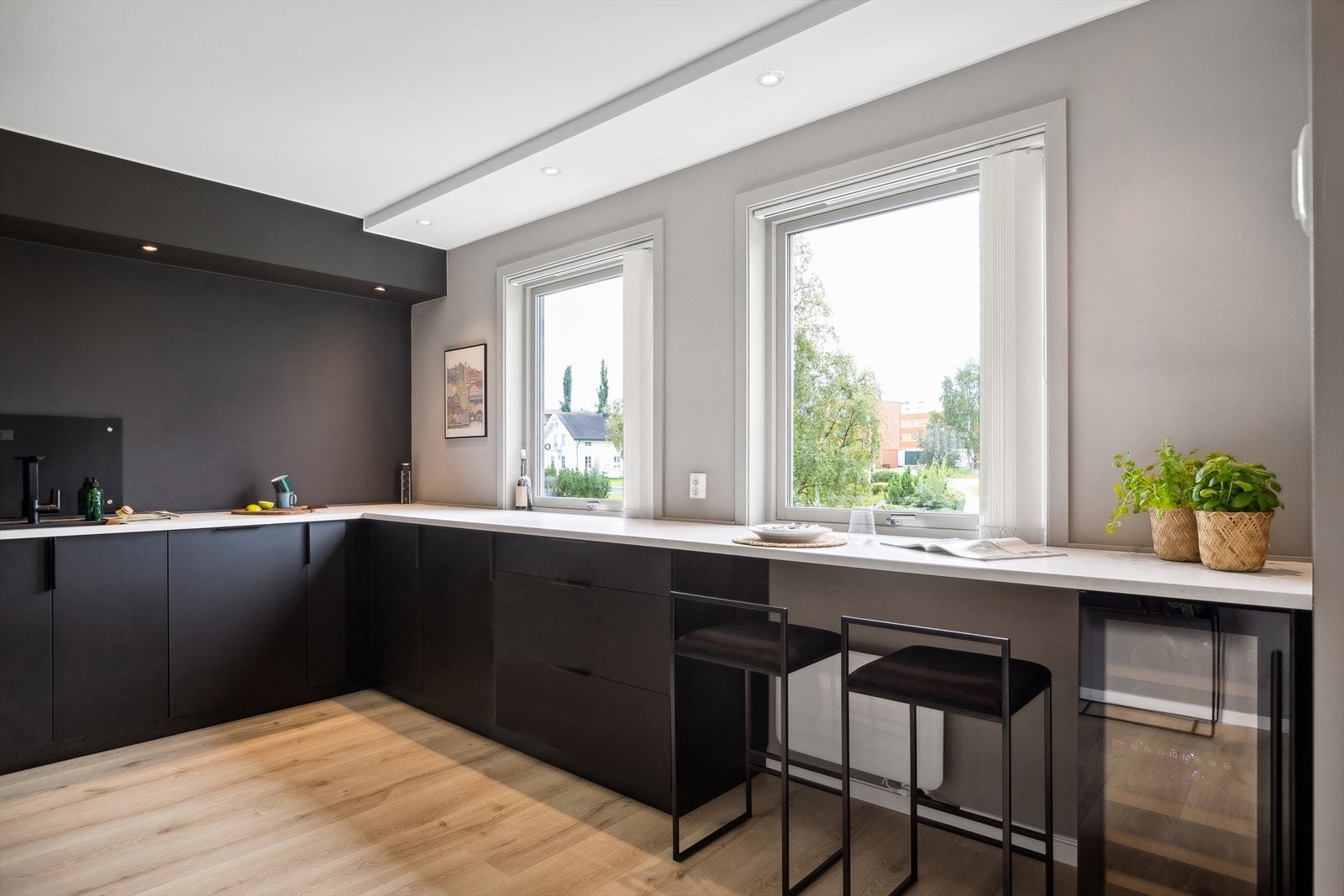 Folierte skrog med slette fronter og laminert benkeplate. Glassplate på vegg over benkeplate ved oppvaskkum og platetopp. Det er etablert avtrekk med kullfilter Galleribilde