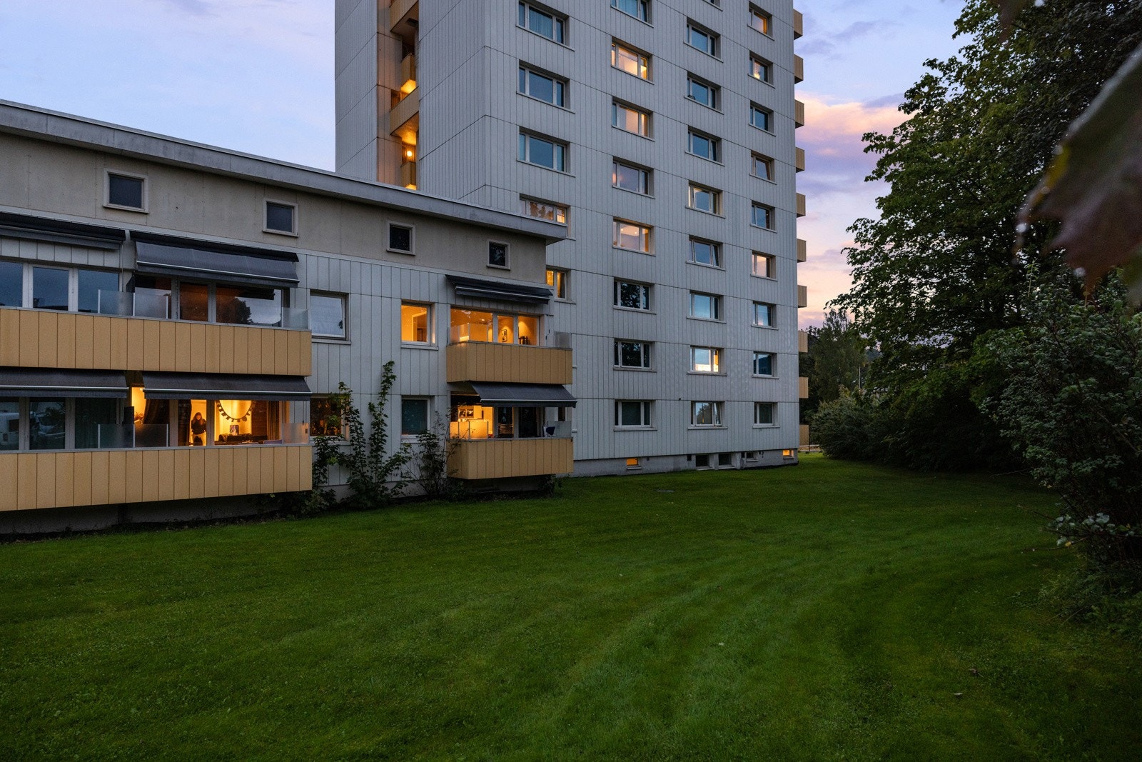 Rundt bebyggelsen har borettslaget fellesareal som er pent opparbeidet med grønne plener Galleribilde