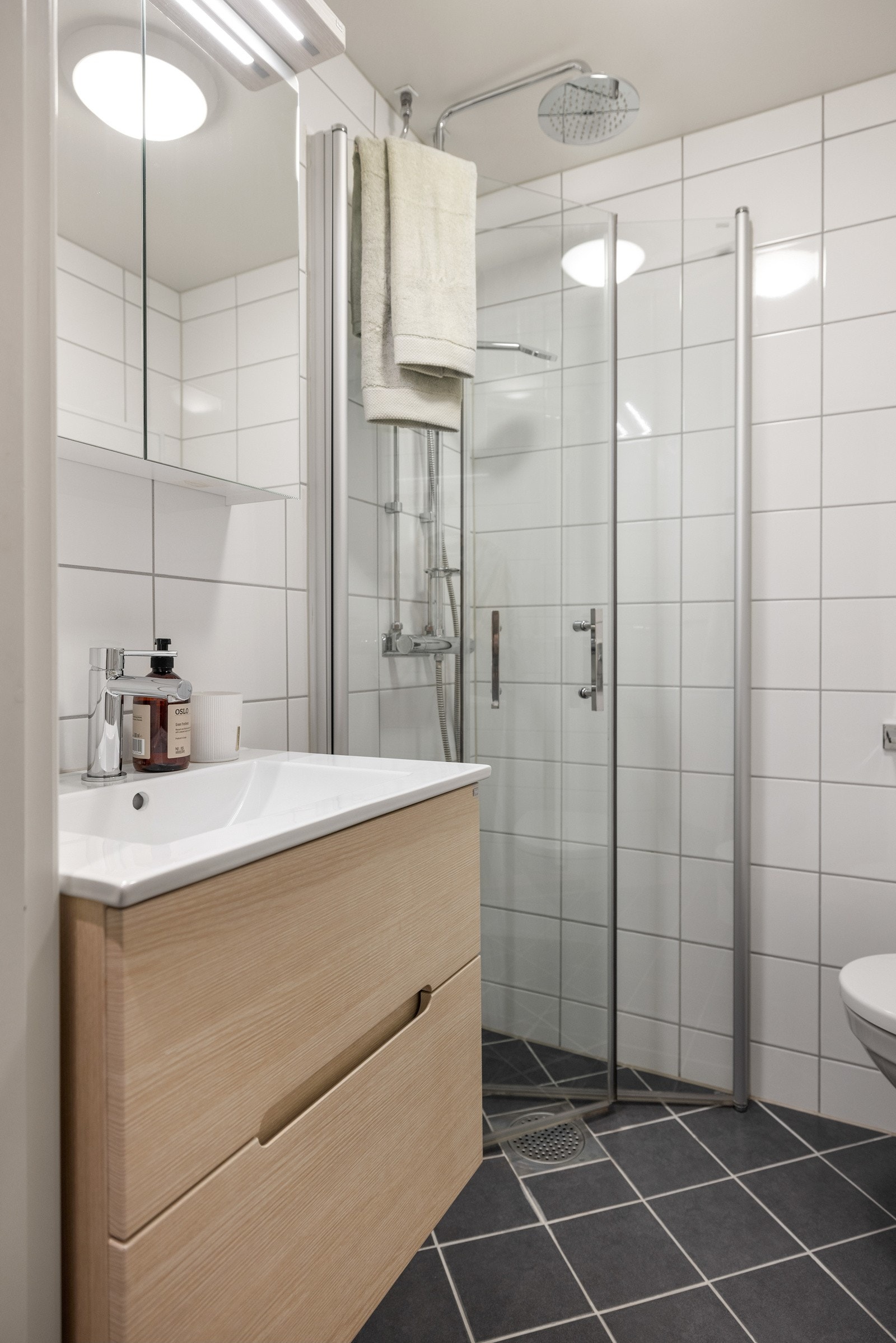 Bad ble pusset opp i regi av borettslaget i 2018 og gir et delikat inntrykk med flislagte overflater, gulvvarme, downlights og mekanisk avtrekk Galleribilde