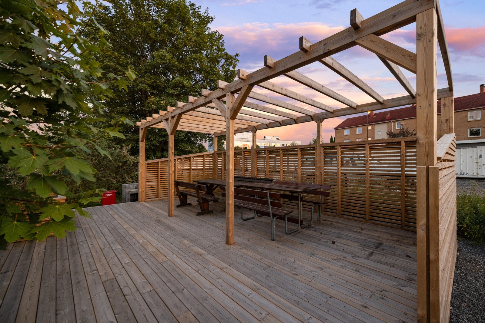 Plenarealet prydes med trær og busker, og blant det grønne er det også en koselig, felles uteplass med levegger, pergola, sittebenker og grill Galleribilde