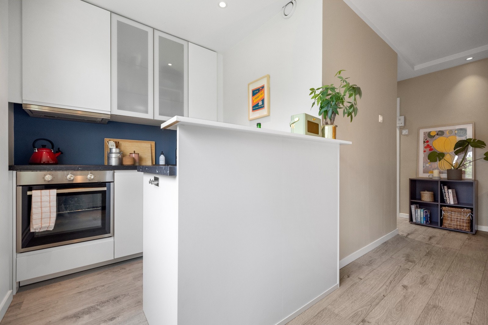 Kjøkkenet ligger avdelt fra stuen med en smart halvvegg, downlights i himling og stilren innredning fra 2019 Galleribilde