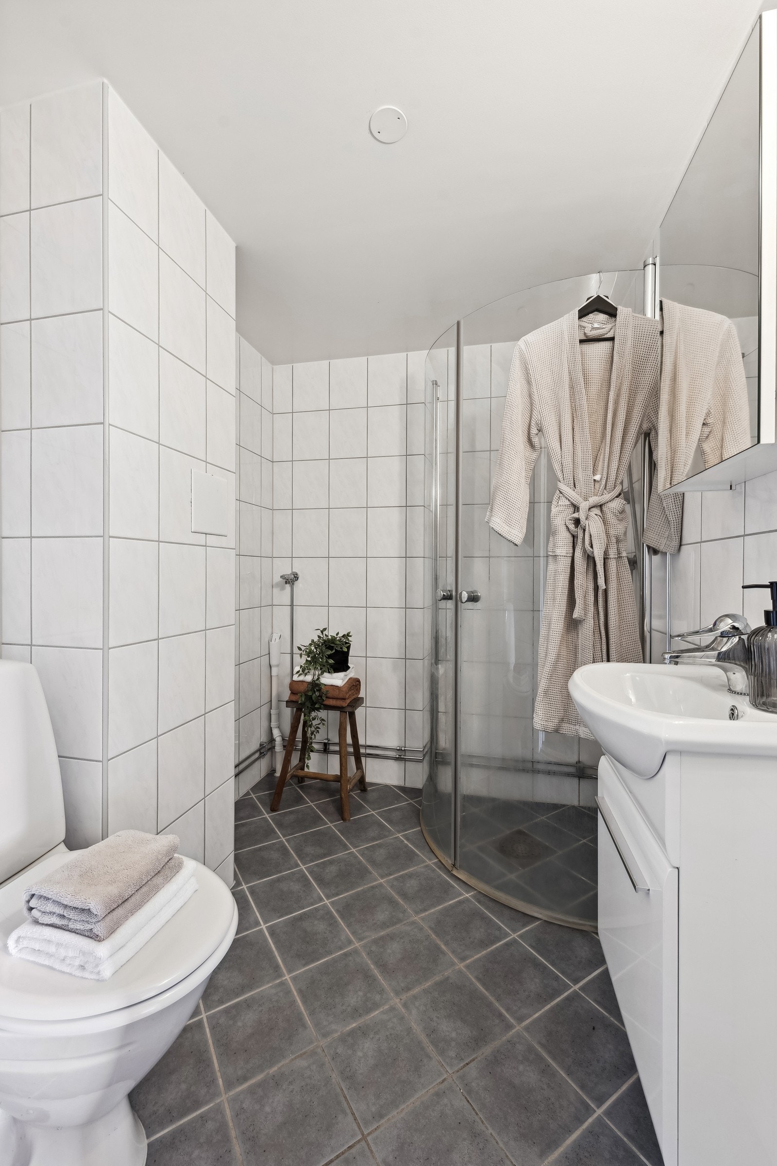 Bad med servant med innredning, toalett, dusj med skyvevegger og opplegg for vaskemaskin. Galleribilde