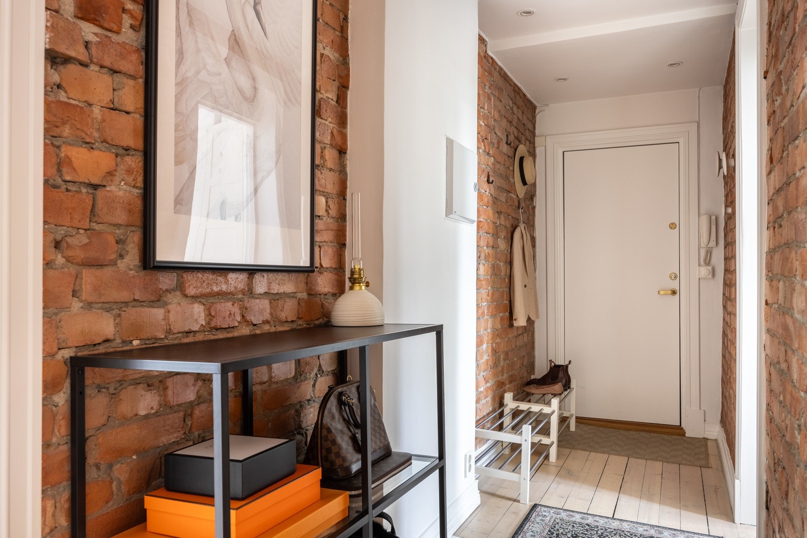 Lys og romslig entré med originale tregulv og teglsteinsmur. Galleribilde