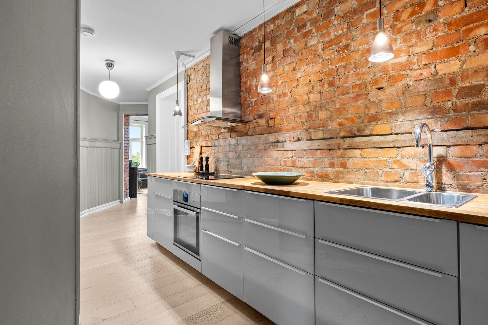 Kjøkkenet utstyrt med integrerte hvitevarer som oppvaskmaskin, kjøl-/fryseskap, stekeovn og koketopp, samt kullfilterventilator, komfyrvakt og waterguard Galleribilde