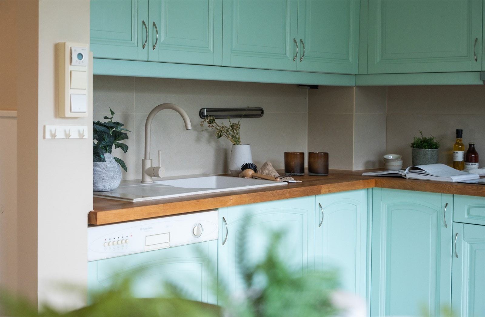 Kjøkkeninnredning med profilerte fronter og heltre benkeplate. Flislagte vegger over benkeksap. Galleribilde