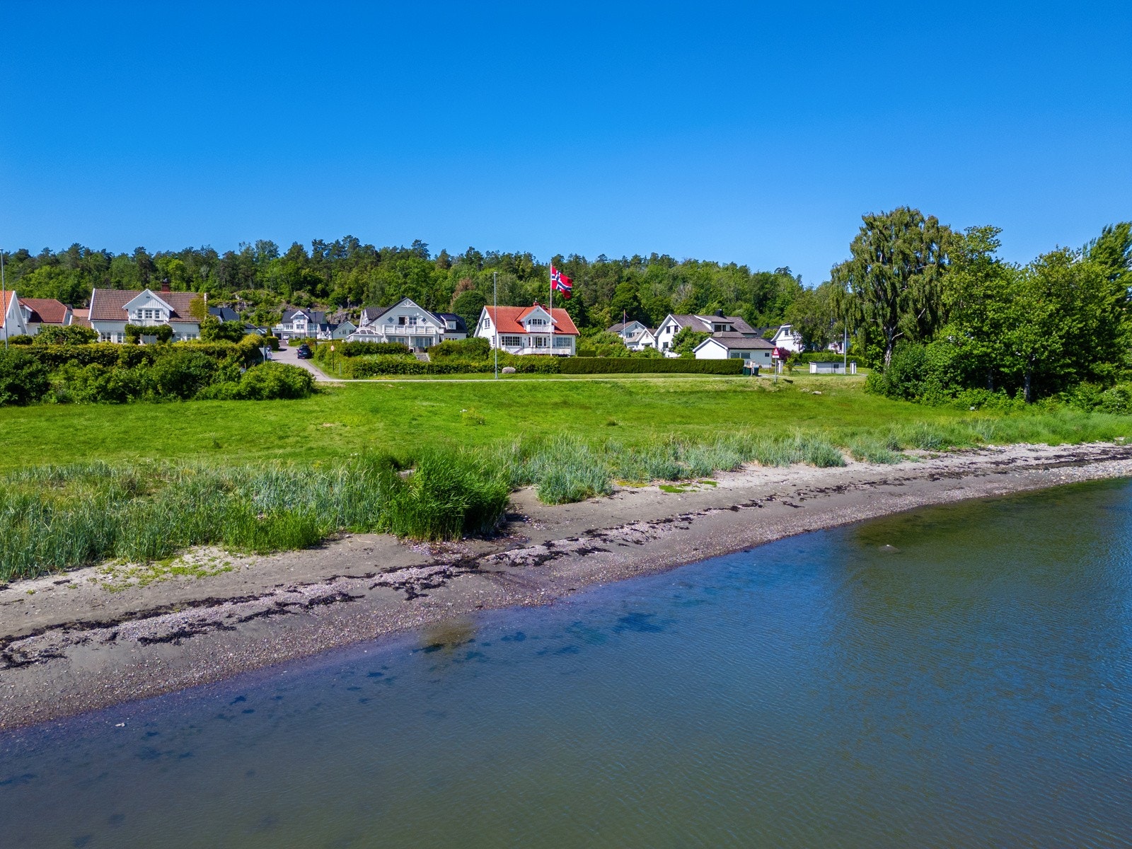 Eiendommen sett fra sjøen. Her er det offentlig badeplass ca 50 meter fra eiendommen! Galleribilde