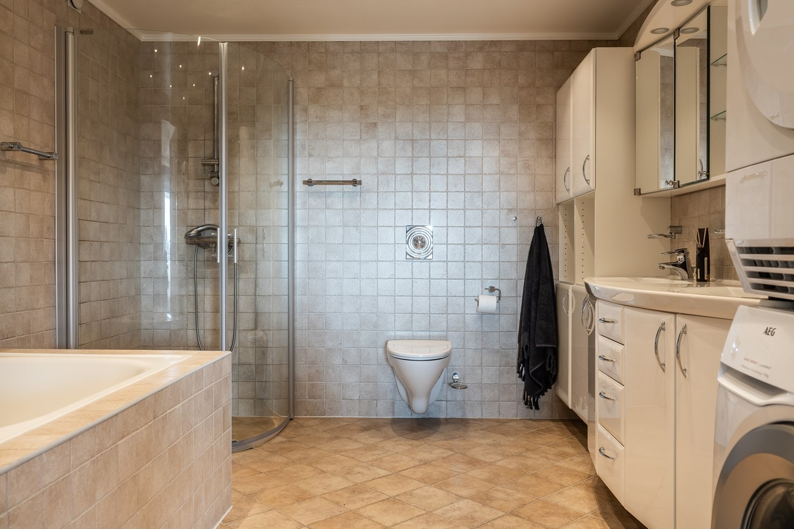 Hovedbad med både dusj, badekar og opplegg for vaskemaskin og tørketrommel Galleribilde
