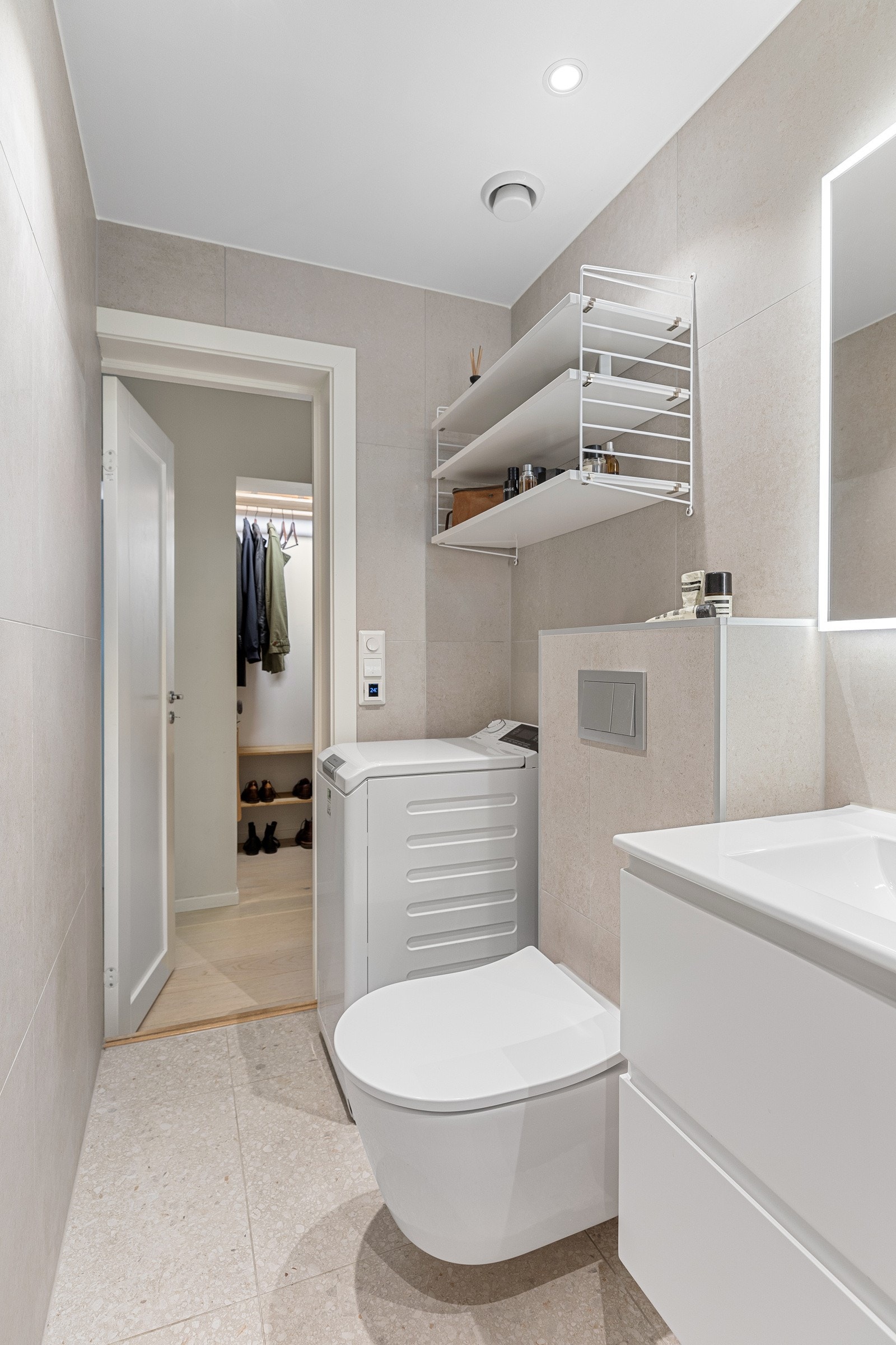 Badet byr blant annet på delikate fliser med behagelig gulvvarme og opplegg for vaskemaskin Galleribilde