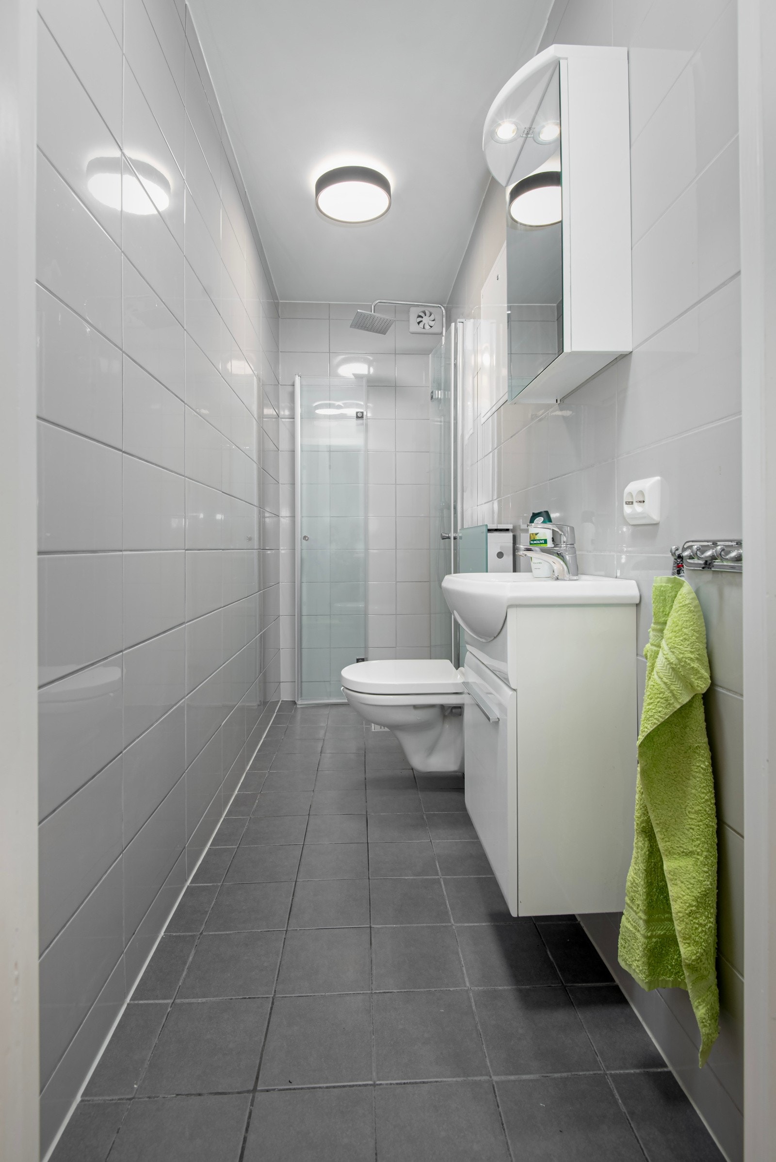 Lyst og helfliset bad med gulvvarme fra 2021. Innredet med servantskap, speilskap - Galleribilde