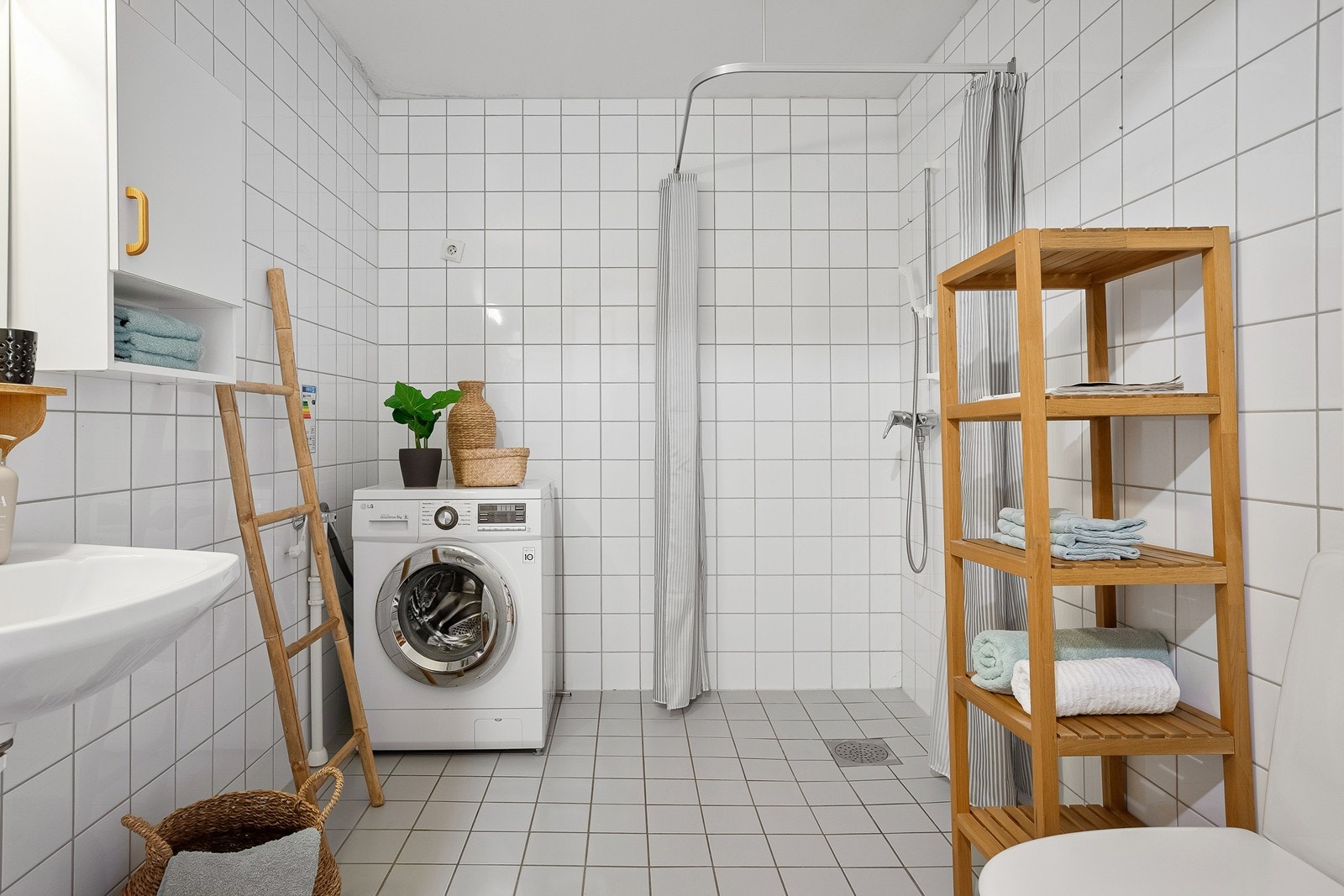 Lyst og fint flislagt bad med gulvvarme. Badet er utstyrt med wc, dusjhjørne, mekanisk avtrekk, opplegg for vaskemaskin, servant og servantskap Galleribilde
