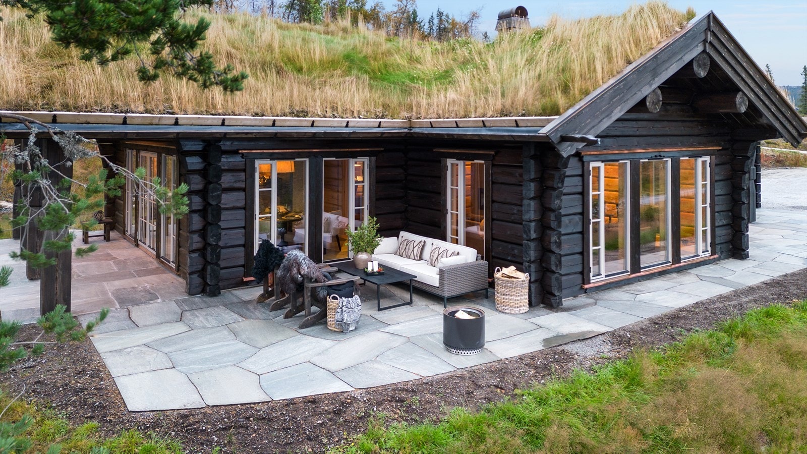 Beliggende på en romslig tomt, har hytten en åpen og luftig planløsning som strekker seg over to etasjer, med store vindusflater som slipper inn rikelig med naturlig lys. Galleribilde