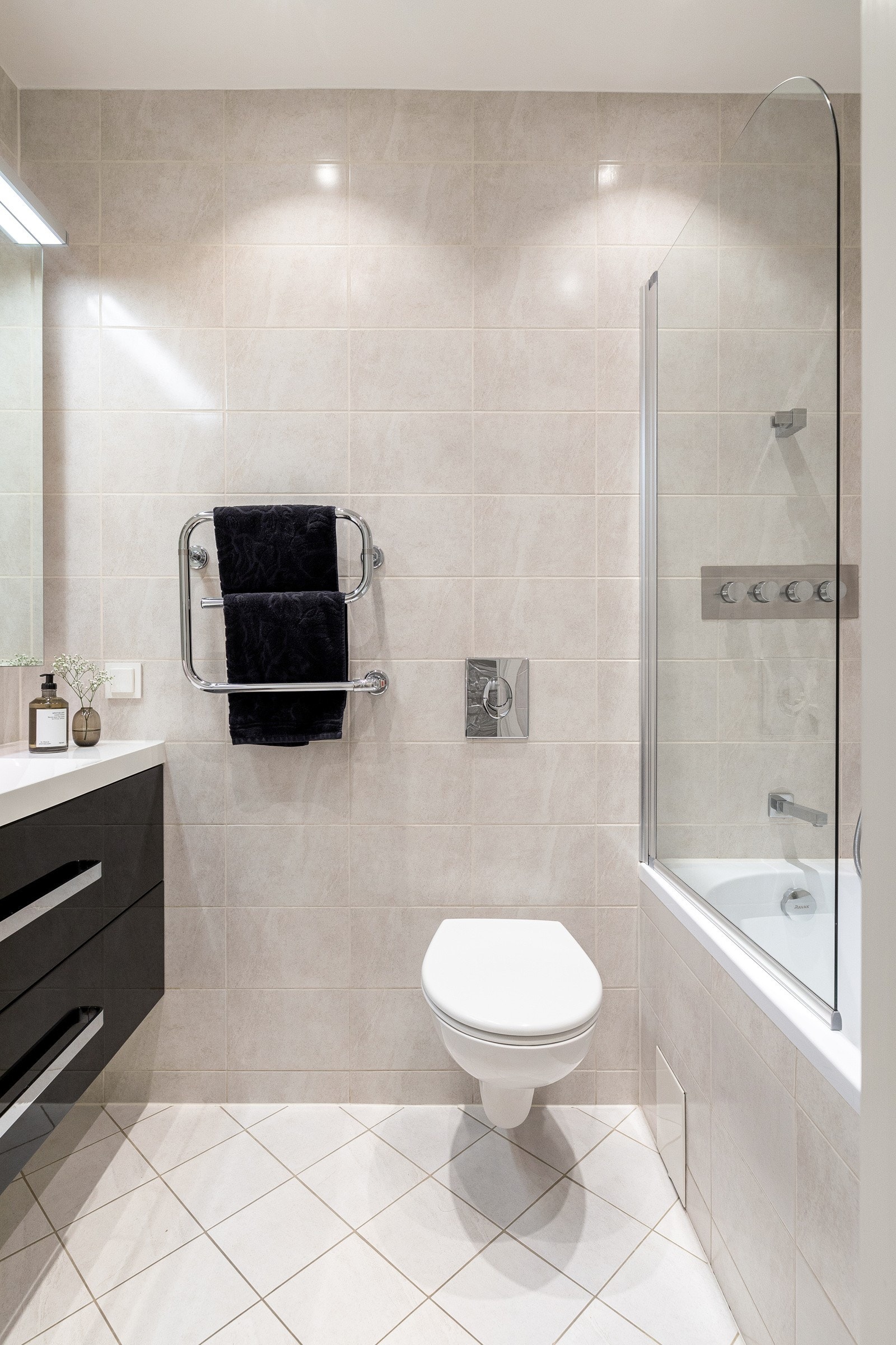 Delikat, flislagt bad med varmekabler i gulv og downlights i himling Galleribilde