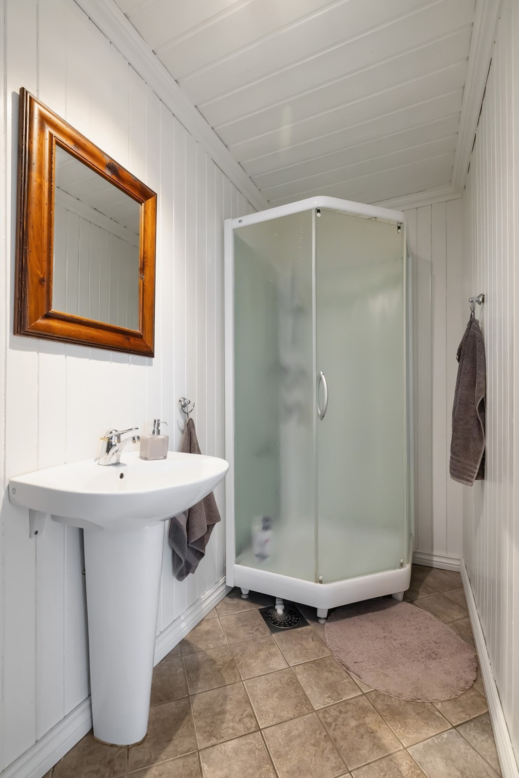 aderom har flislagt gulv med gulvvarme og innredet med dusjkabinett og vask Galleribilde