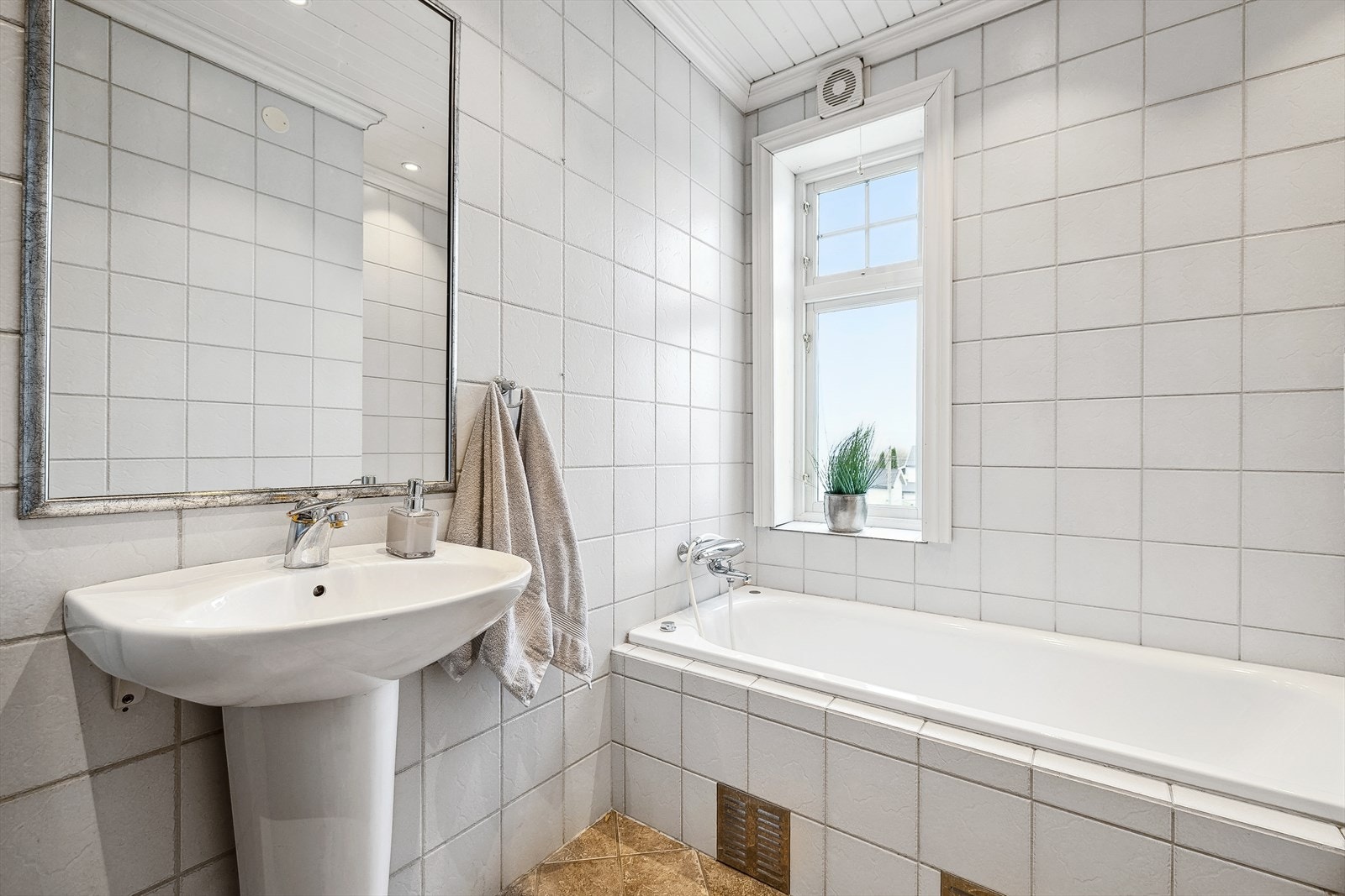 Badet er innredet med servant, badekar, wc og downlights. Galleribilde