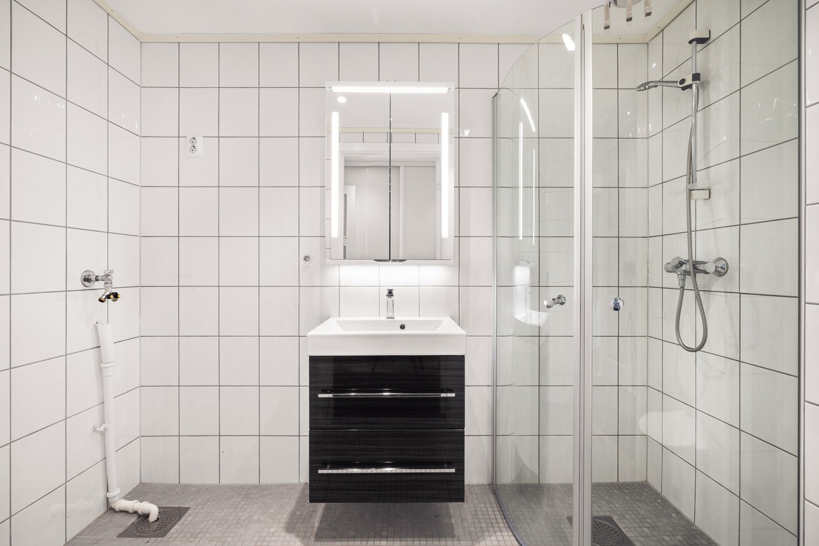 Badet er helfliset og med vegghengt toalett, og opplegg for vaskemaskin. Galleribilde