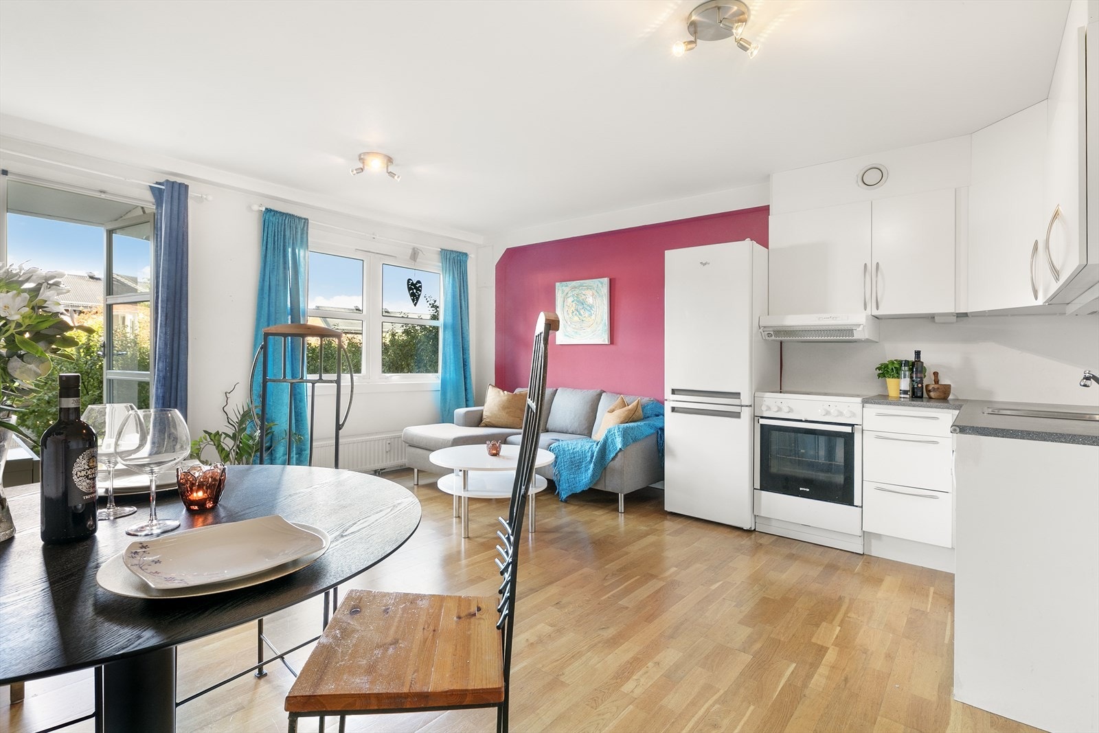 Lunt kjøkken med åpen løsning til en hjemmekoselig stue. Galleribilde