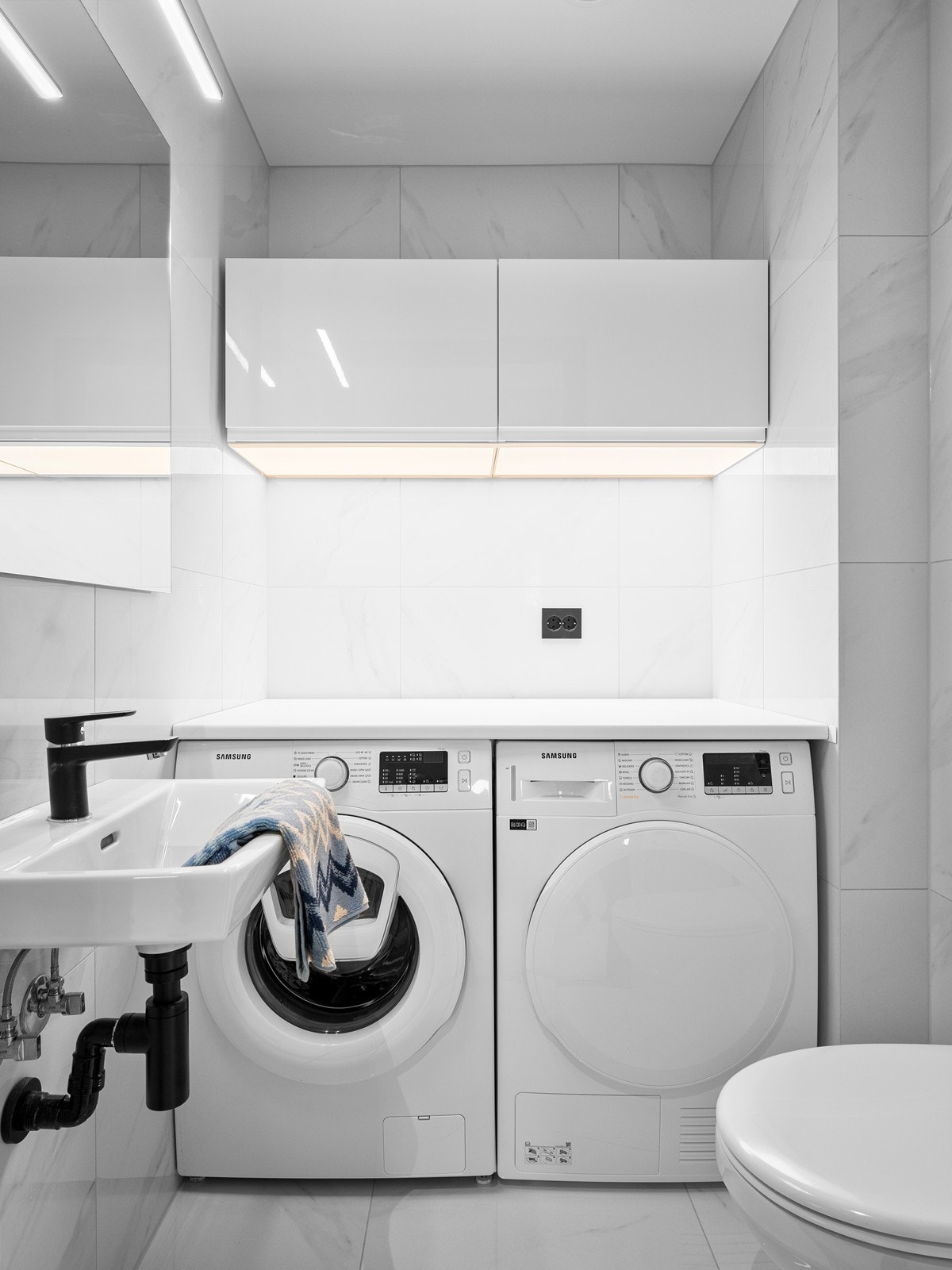 WC/vaskerom som er helfliset med vannbåren gulvvarme. Praktisk og pen innredning med opplegg for vaskemaskin og tørketrommel. Galleribilde