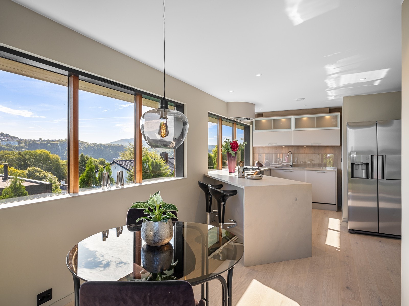 Nydelig utsikt fra store vindusflater og en pen kjøkkeninnredning med integrert stekeovn, platetopp, oppvaskmaskin og vinskap som medfølger i handelen. Galleribilde