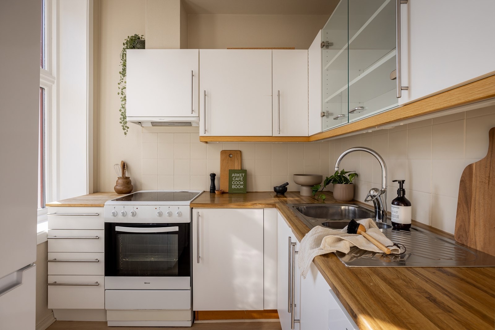 Kjøkkenet er innredet med hvitfolierte fronter i slett utførelse. Benkeplaten er laminert. Galleribilde