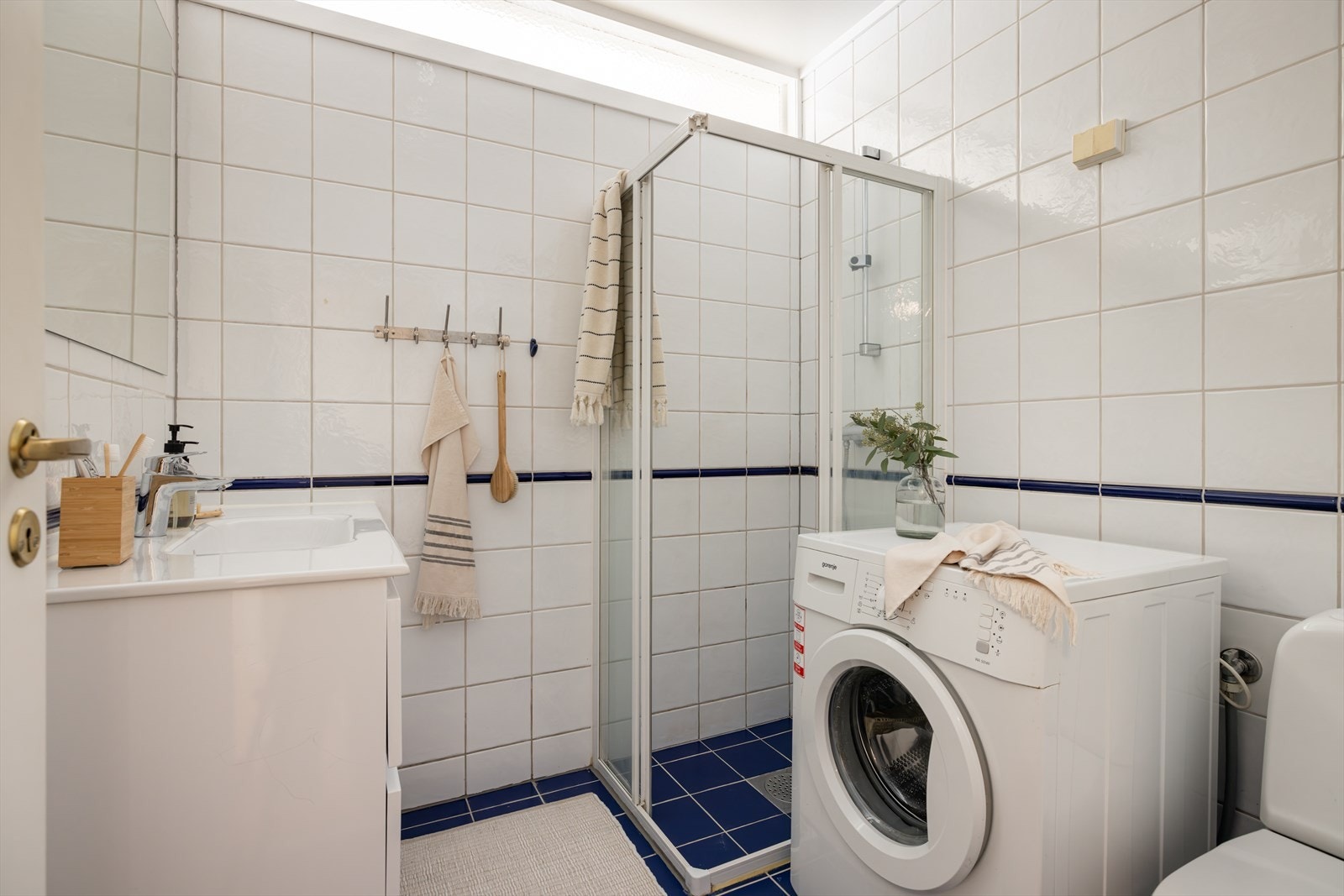 Flislagt bad med lyse fliser på vegger og kontrastfliser på gulv. Galleribilde