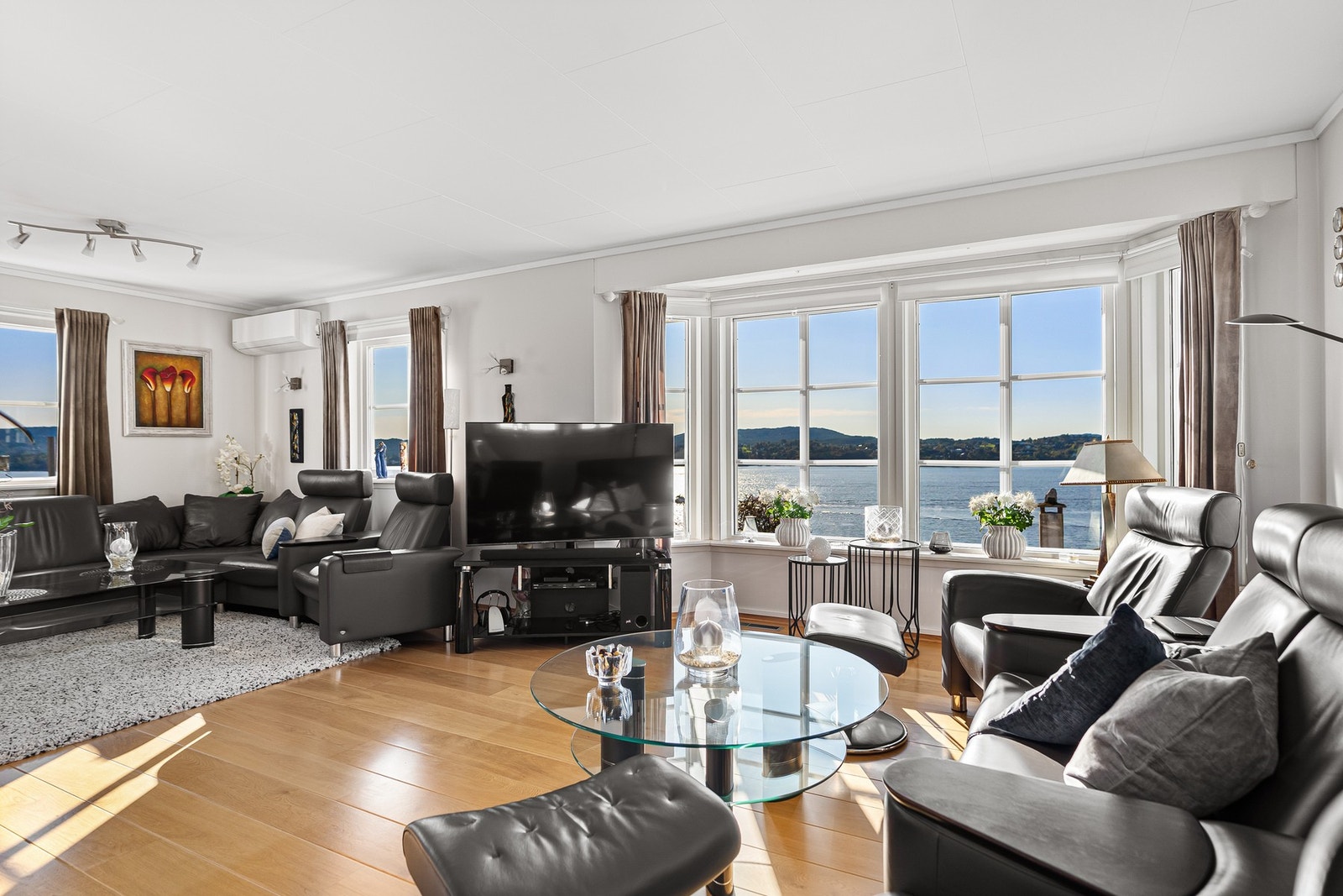 Stuen har enstavs parkett mot hvitmalte overflater Galleribilde