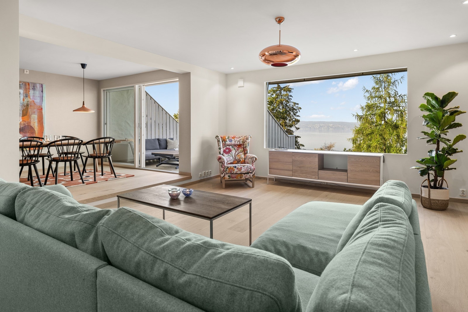 Stue mot spisestue i 2. etasje store vindusflater åpner boligen opp mot fjorden. Galleribilde