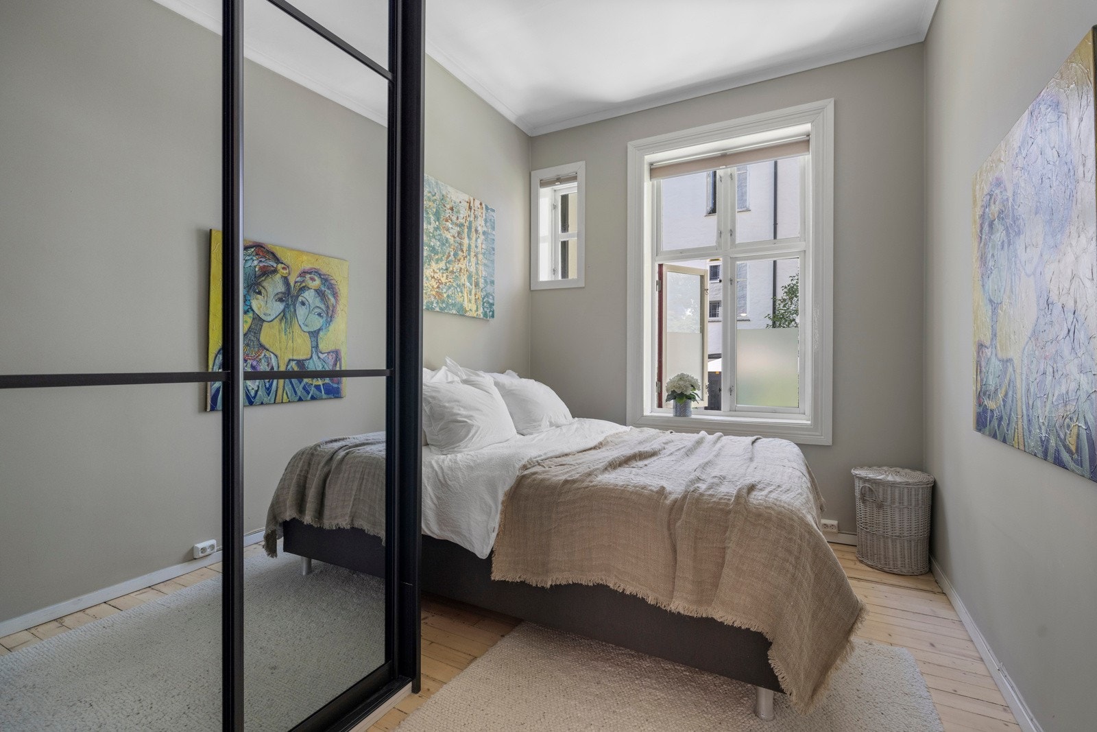 Innbydende soverom med god plass til stor dobbeltseng samt tilhørende nattbord. Store vindusflater slipper inn naturlig lys og vender ut mot en rolig bakgård. Galleribilde