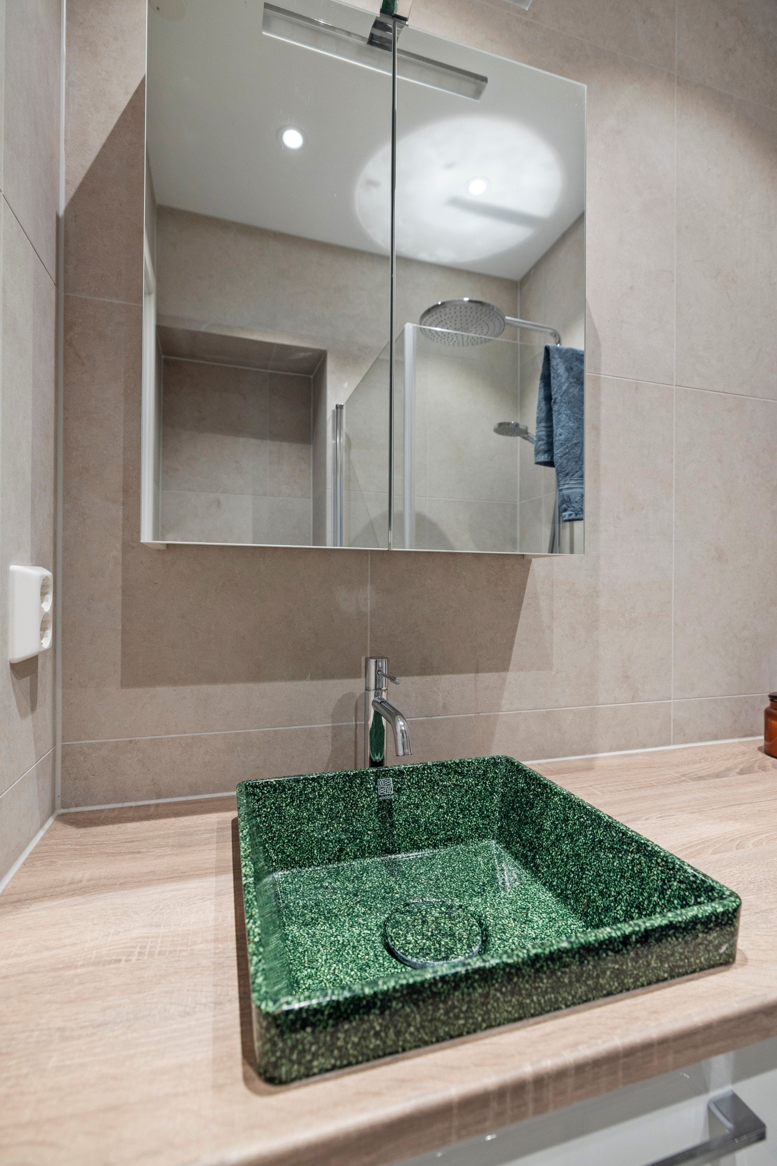 Innbydende baderomsinnredning med delikat vask og skap med tilhørende speil. Galleribilde