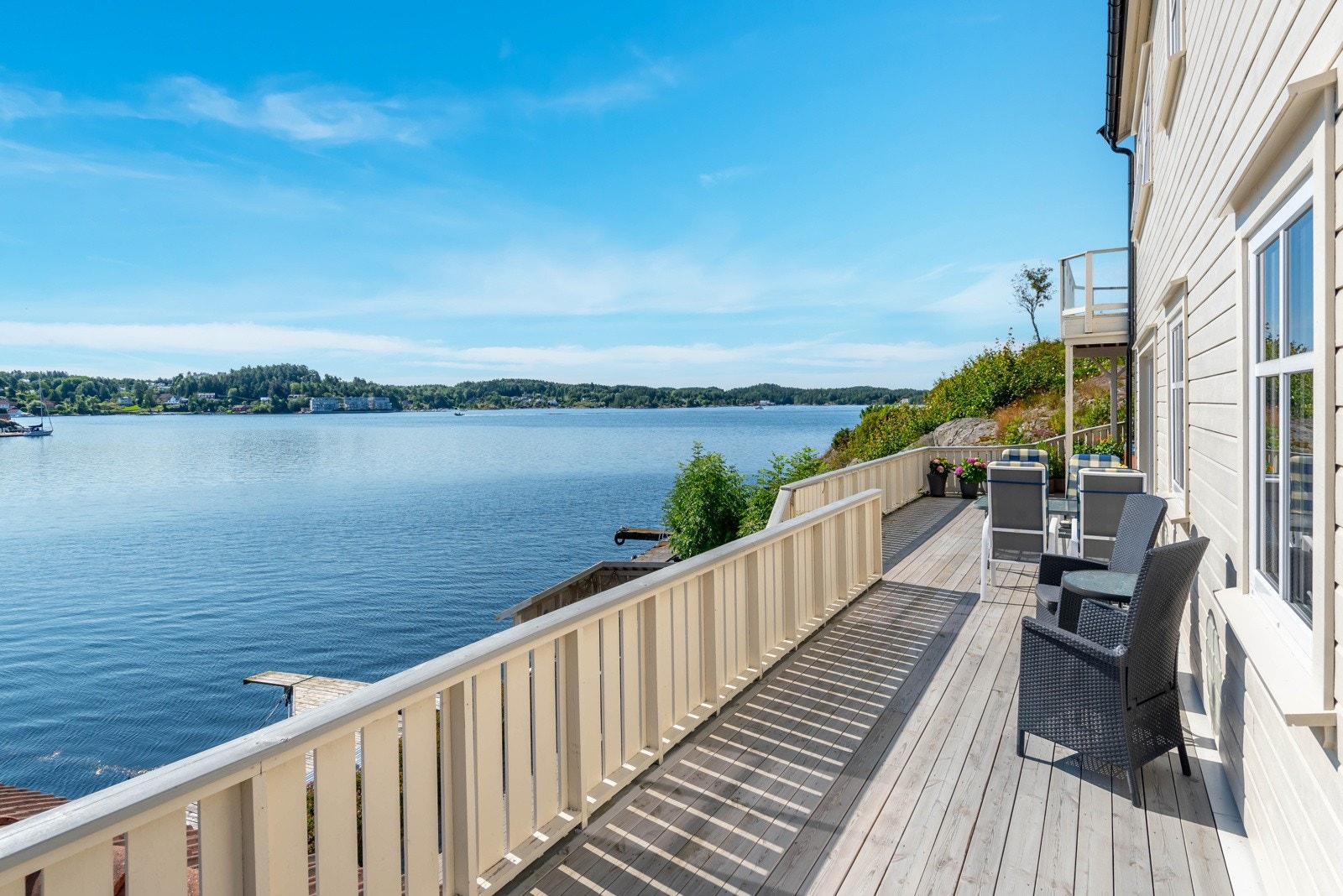 Terrassen strekkser seg langs med fasaden mot sjøen, og har trapp ned til kjelleretasje og brygge. Galleribilde