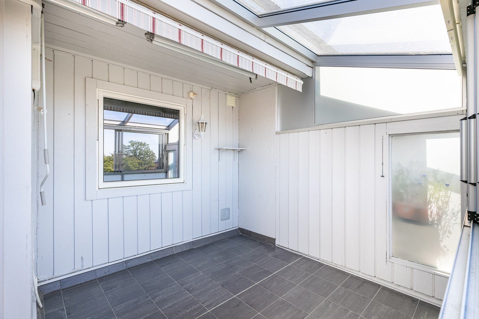 Balkonggulvet er helhetlig utført med fliser. Innglassing gjør det mulig å sitte ute på balkongen selv om sommerværet ikke er på sitt aller beste. Galleribilde
