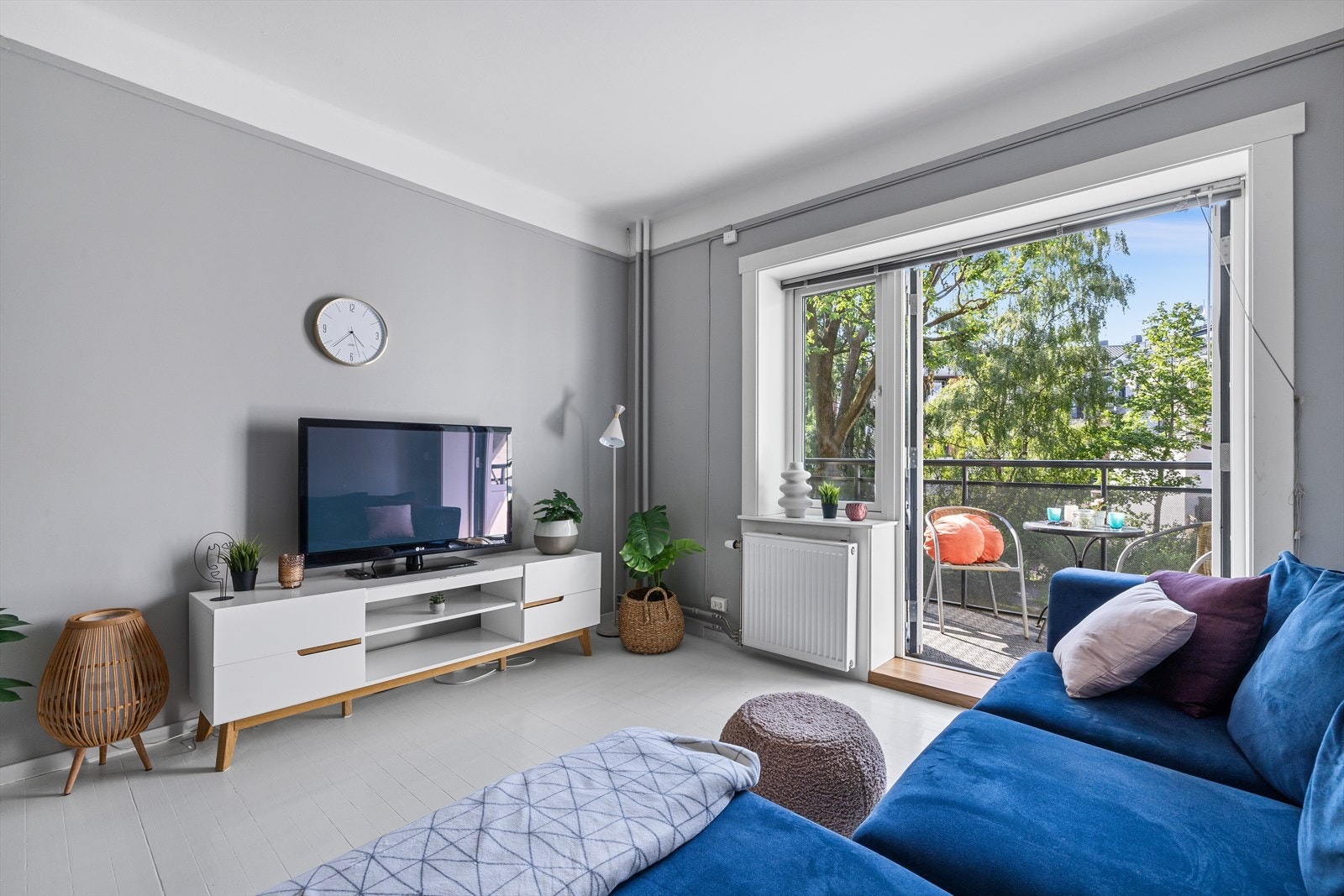 En innbydende stue med tidløst fargevalg og utgang til en flott balkong med utsikt over grønne omgivelser. Galleribilde