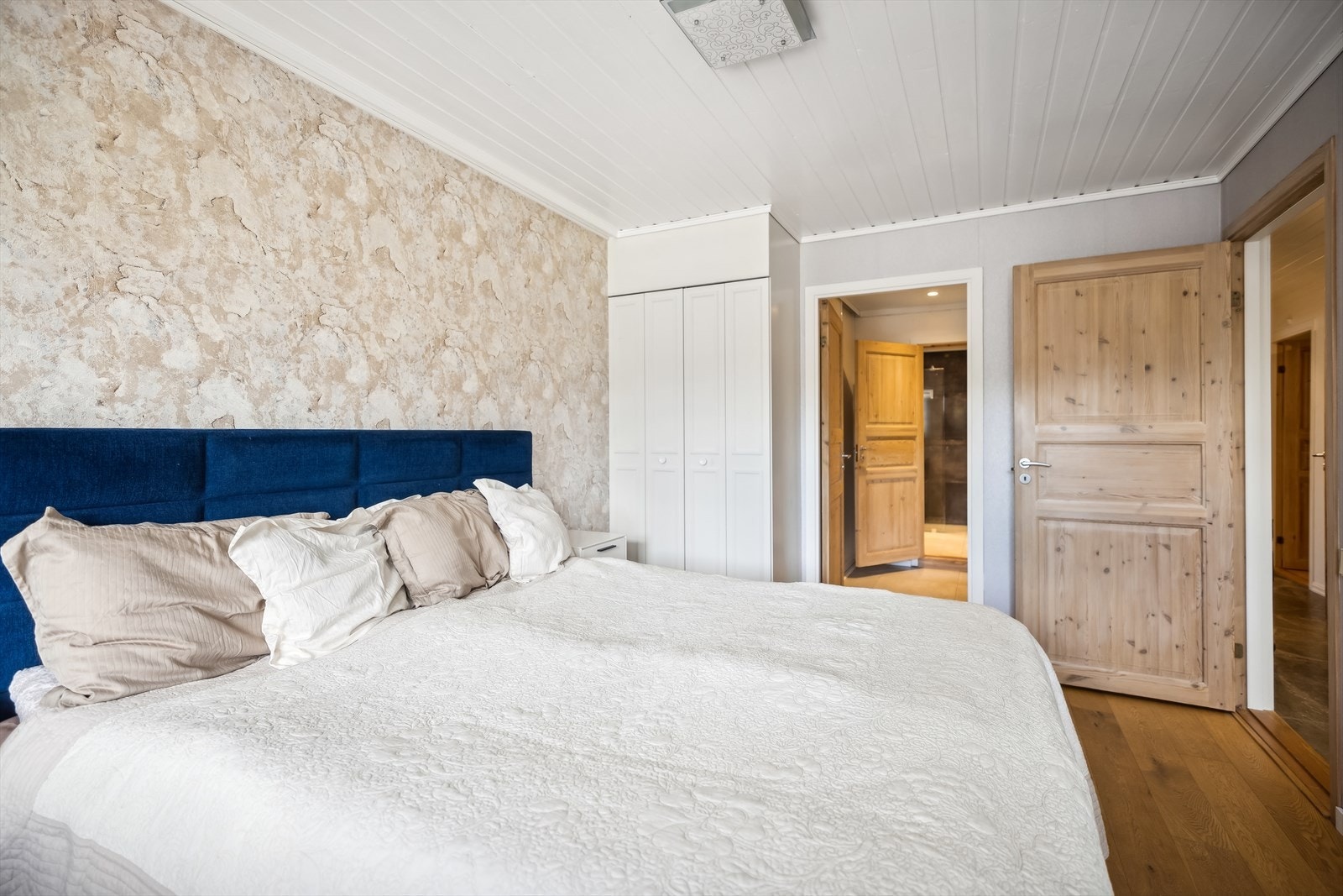 Soverommet byr på god plass til bred seng, tilhørende nattbord på hver side, og garderobe i tillegg til walk-in. Galleribilde
