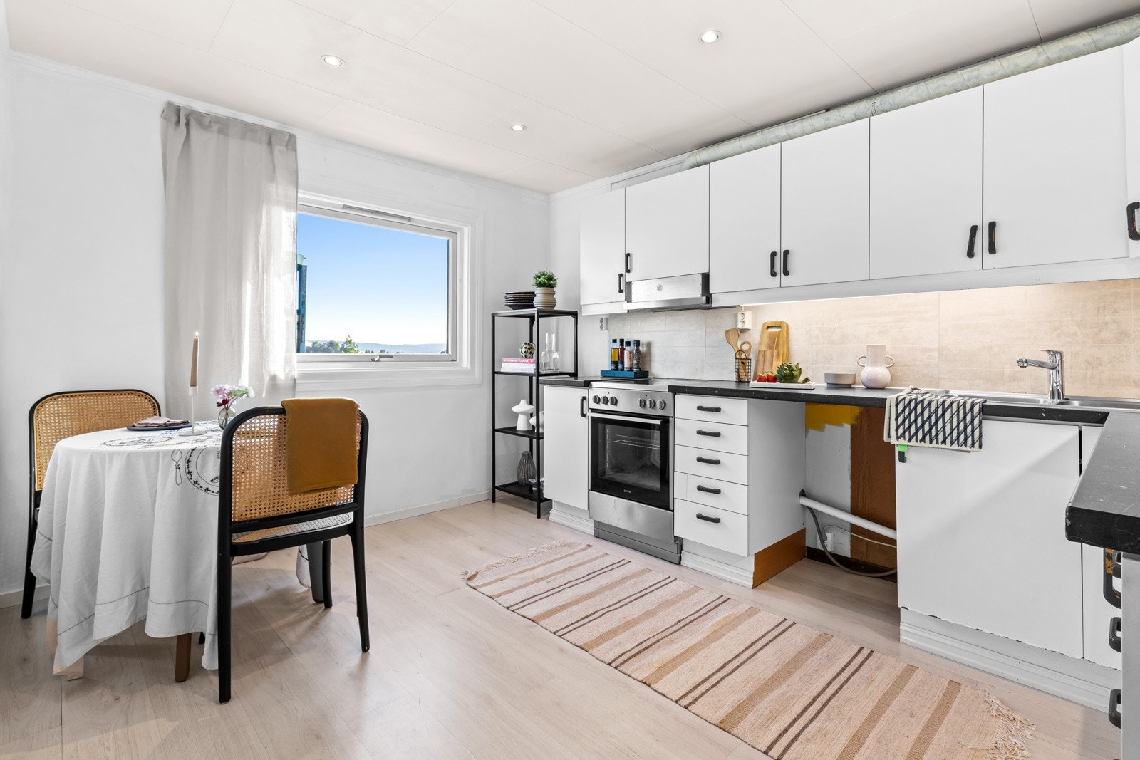 Kjøkkenet er separat og har hvite glatte fronter med laminat benkeplate. Her er det også plass til en spisegruppe. Galleribilde