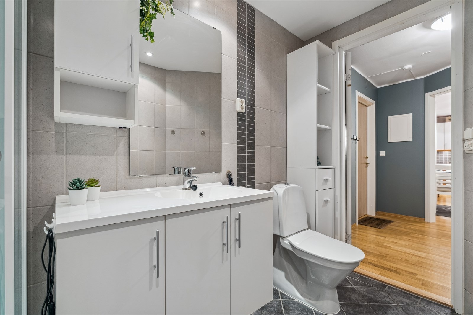 Badet er utstyrt med en romslig innredning, høyskap, toalett, dusjkabinett og opplegg for vaskemaskin. Galleribilde