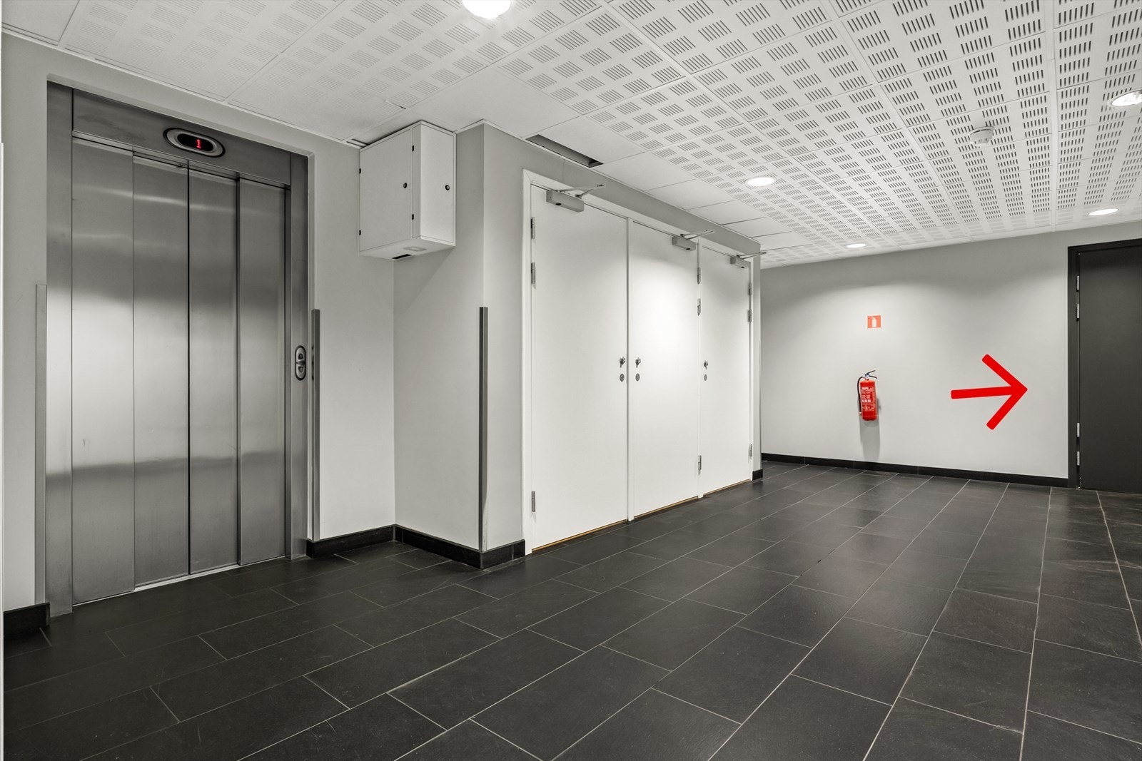 Leiligheten ligger i 2.etasje med heisadkomst og kort avstand til leiligheten (markert med pil) Galleribilde