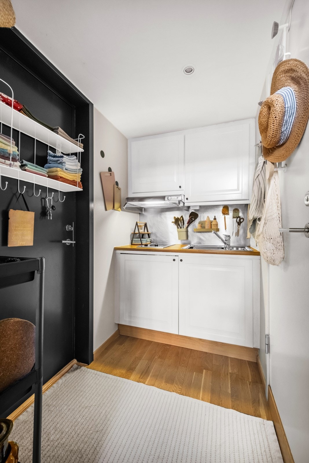 Kjøkkeninnredning med profilerte fronter fra 2024 og foliert benkeplate. Kjøkkenet er utstyrt med platetopp, kum med ettgreps blandebatteri, ventilator og kjøleskap. Galleribilde