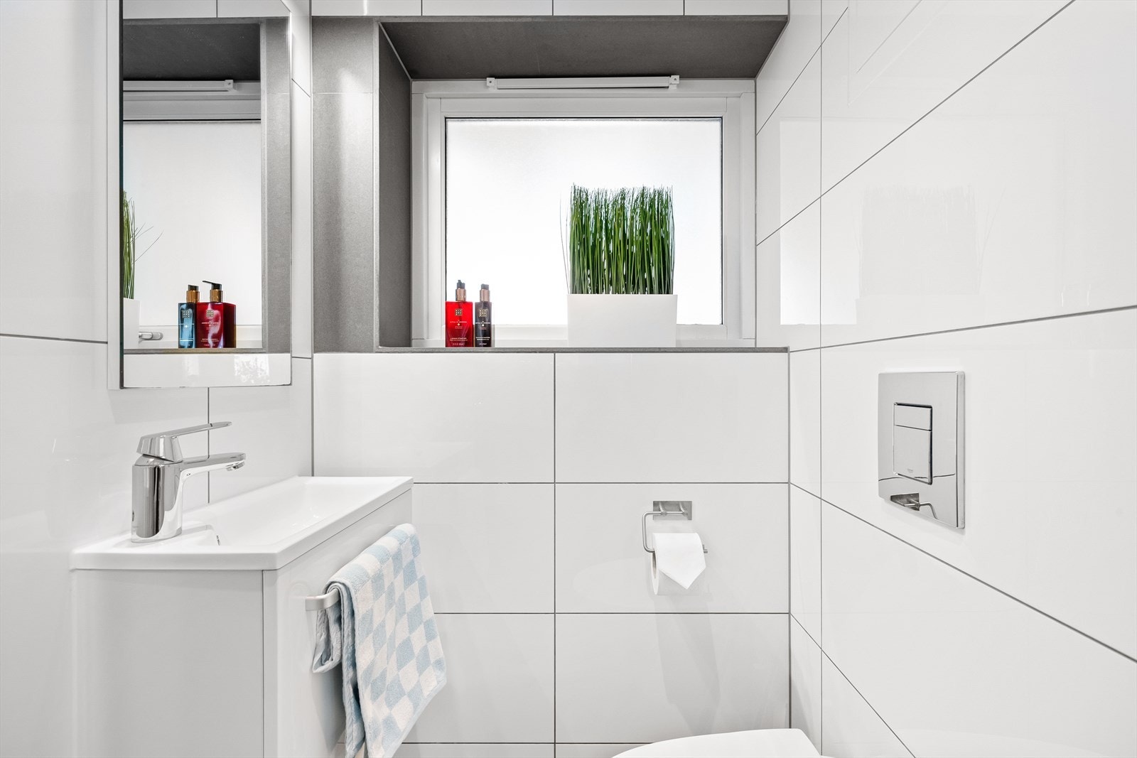 Badet er fullt utstyrt med vegghengt toalett, servant og et dusjhjørne med foldbare glassdører som sikrer optimal utnyttelse av plassen. Galleribilde