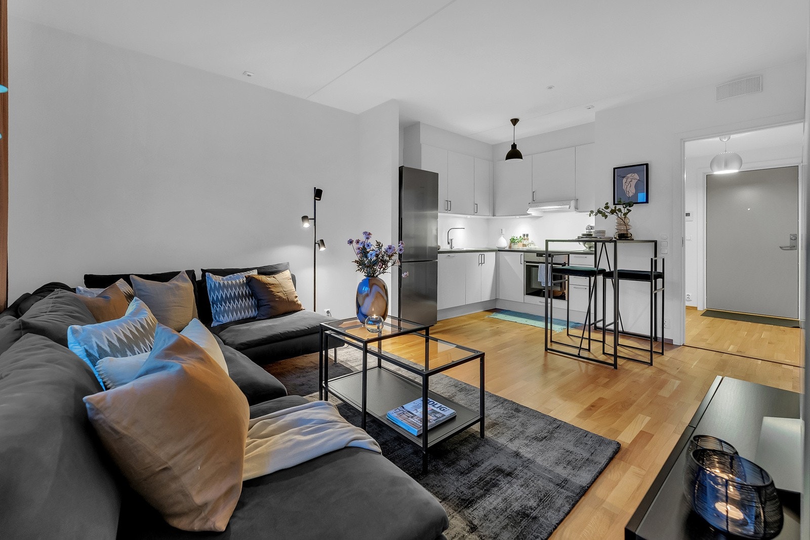 Moderne, lys stue med åpen kjøkkenløsning og stilrent interiør. Galleribilde