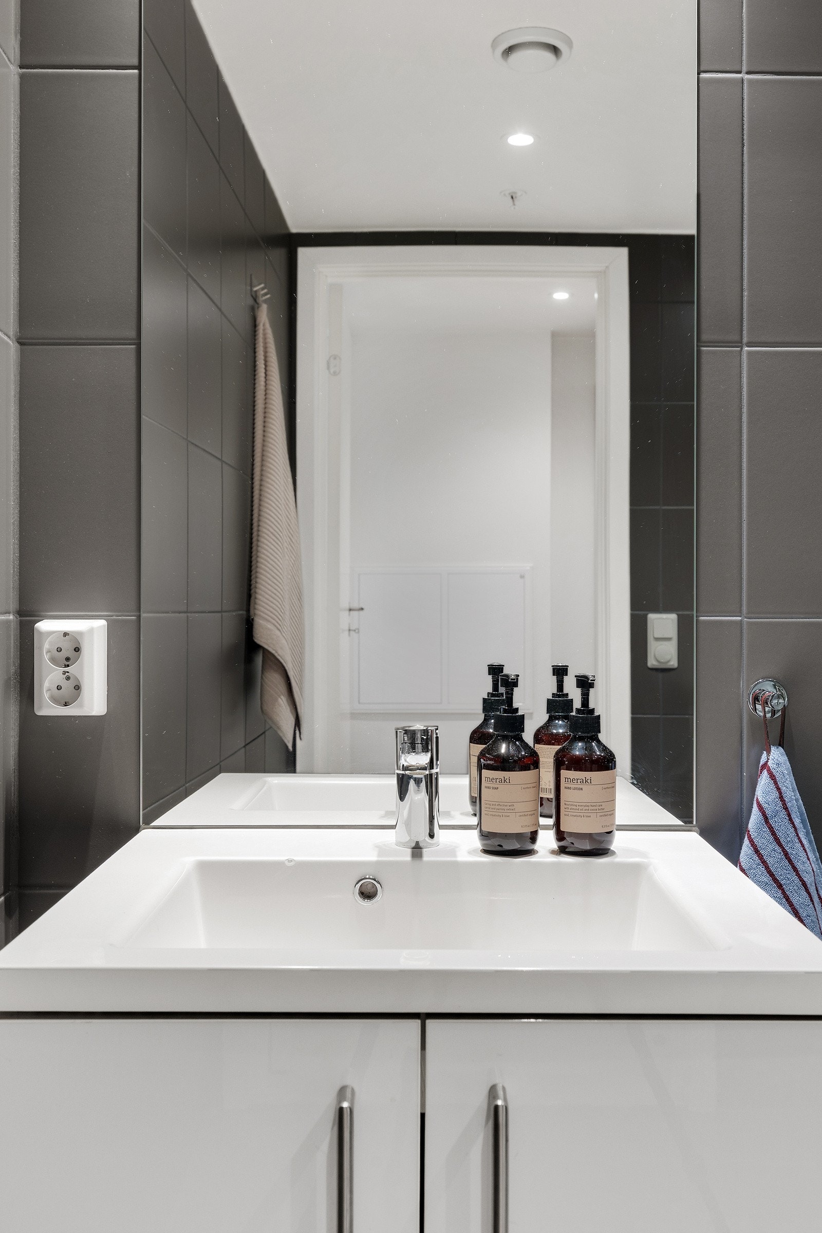 Tidløs baderomsinnredning med heldekkende servant og stort speil over. Galleribilde