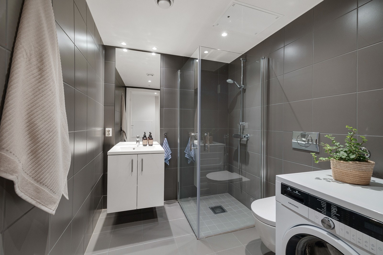 Leiligheten har et stilrent og moderne flislagt baderom fra byggeåret 2019. Galleribilde