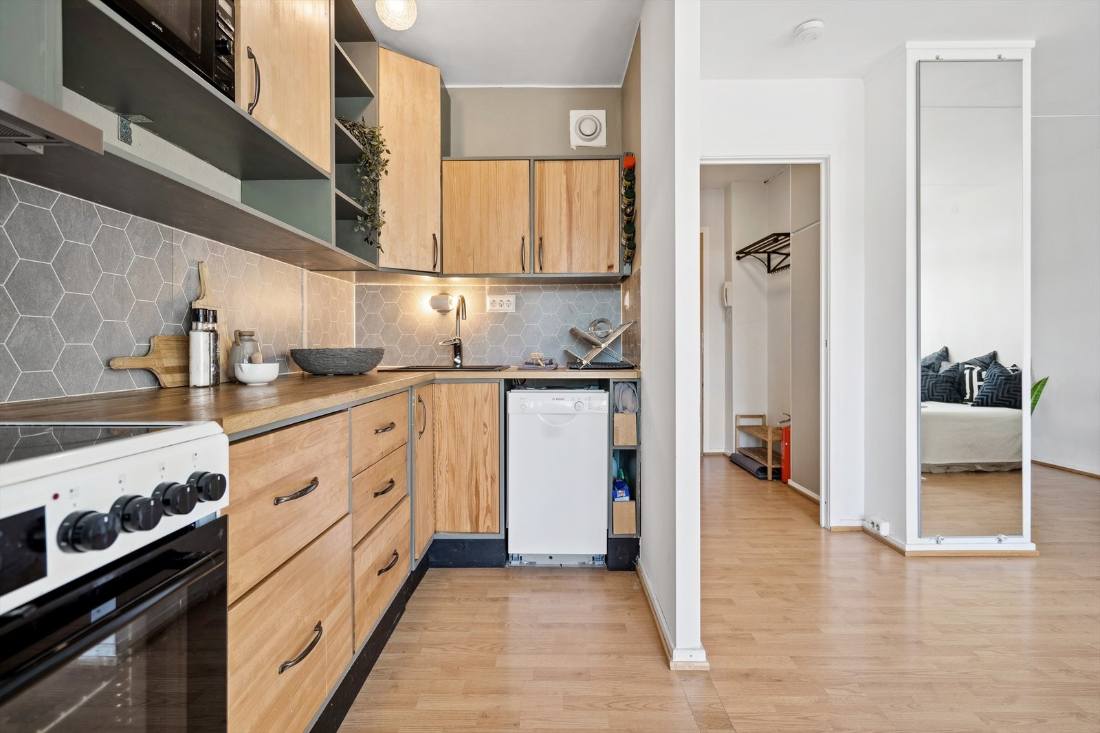 Det er laminat mellom benk og overskap. Alle hvitevarer medfølger. Galleribilde