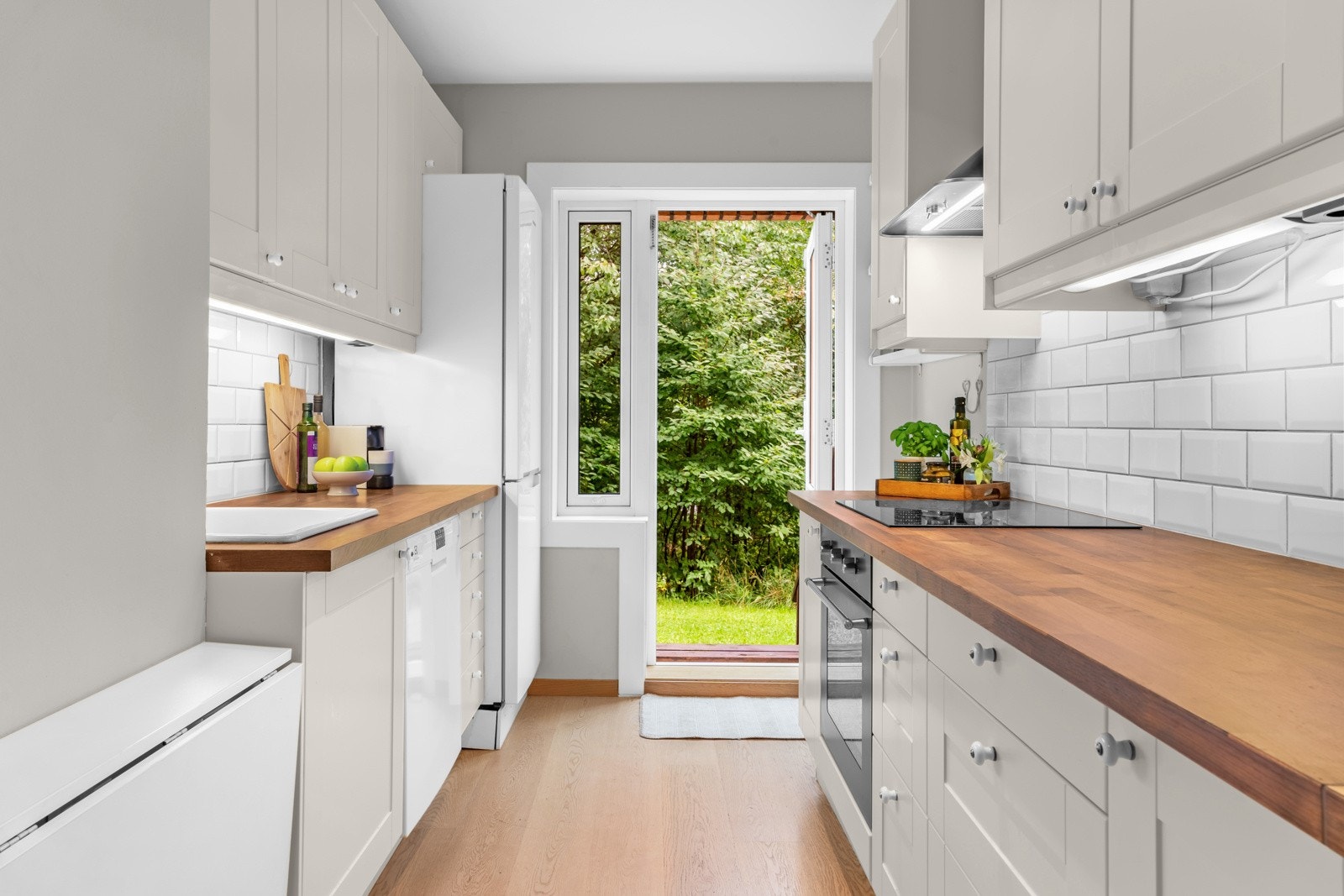 Lyst og pent kjøkken med god skapplass i over- og underskap, samt godt med arbeidsbenk. Det er montert lys under overskap som gir godt lys til matlagingen. Kjøkkeninnredningen er fra IKEA og har profilerte fronter. Galleribilde