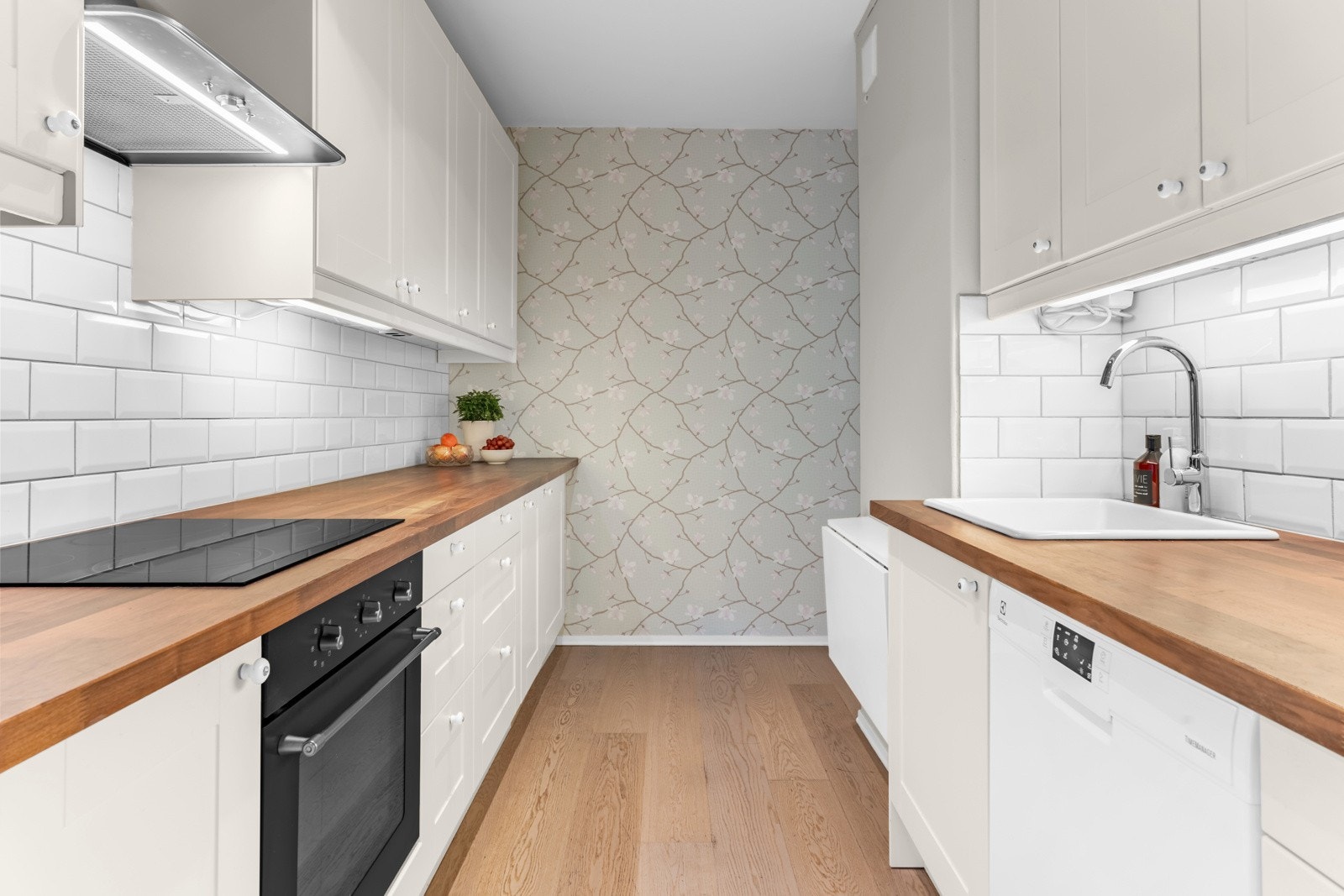 Laminat benkeplate med nedfelt kum i porselen og fliser på vegg over benkeplaten. Kjøkkenet har integrerte hvitevarer som platetopp og stekeovn. Frittstående kjøle-/fryseskap og ny oppvaskmaskin fra 2023. Alle hvitevarer på kjøkken medfølger i handelen. Galleribilde