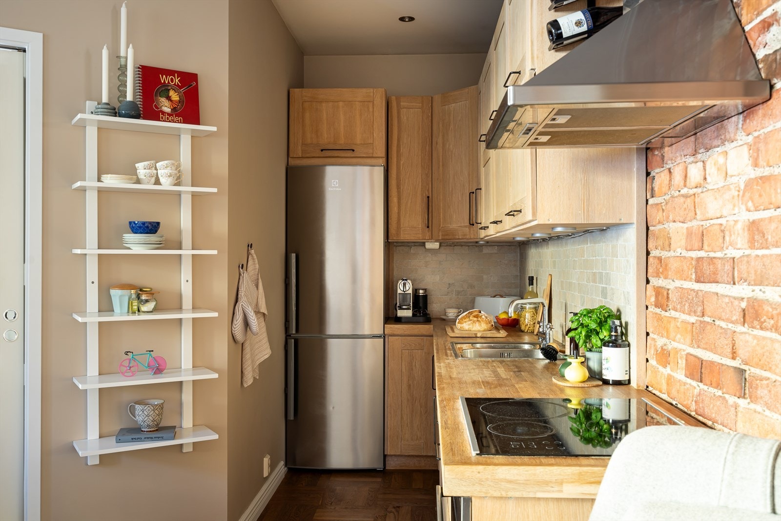 Kjøkkenet er stilrent og praktisk, med innredning og benkeplate i hvitbeiset heltre. Galleribilde