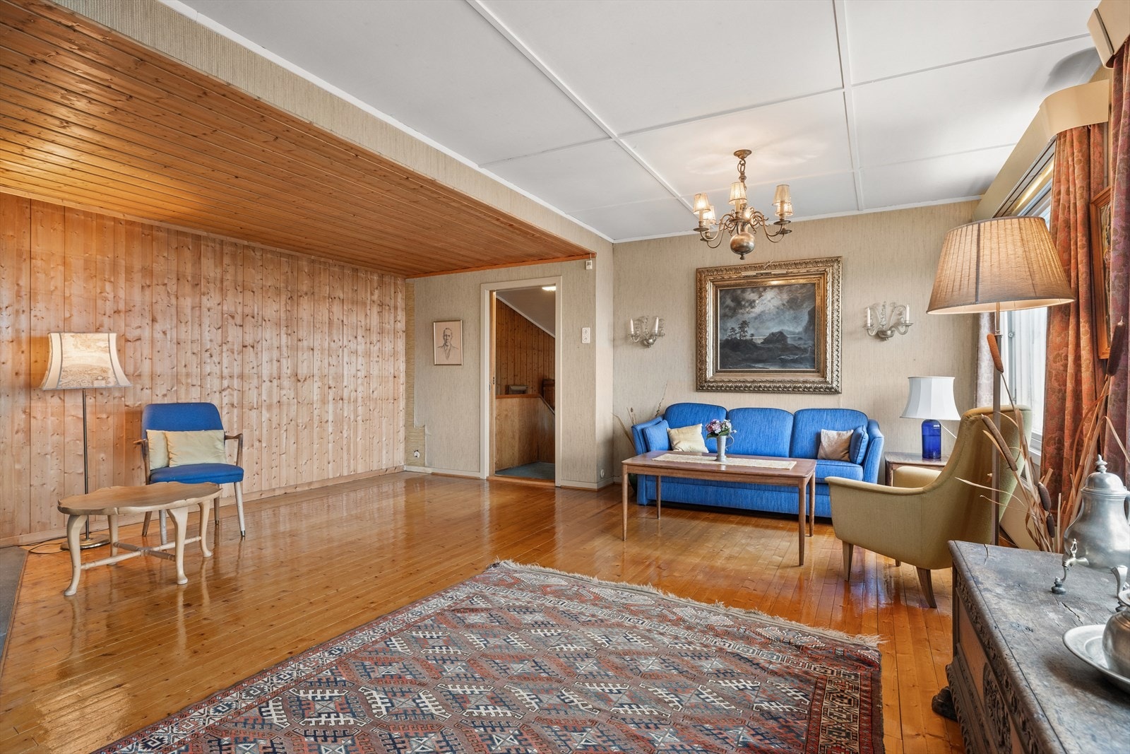 Stor og lys stue med plass til flere sittegrupper Galleribilde