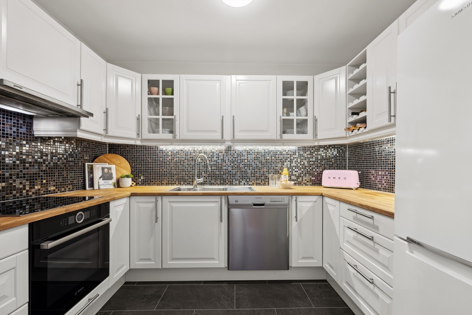 Kjøkkenet er rikelig utstyrt med skap-, skuff-, og benkeplass. Galleribilde