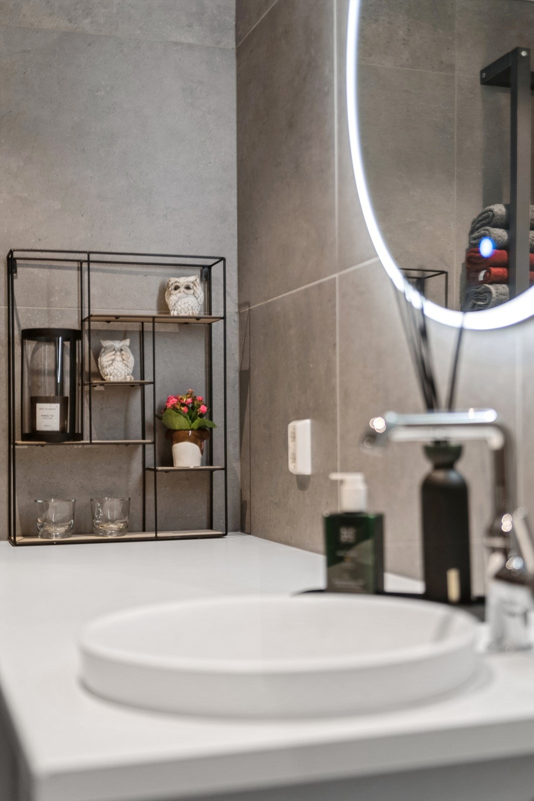 Badet er utstyrt med servant med underskap, opplegg for vaskemaskin og tørketrommel og speil med tilhørende belysning Galleribilde